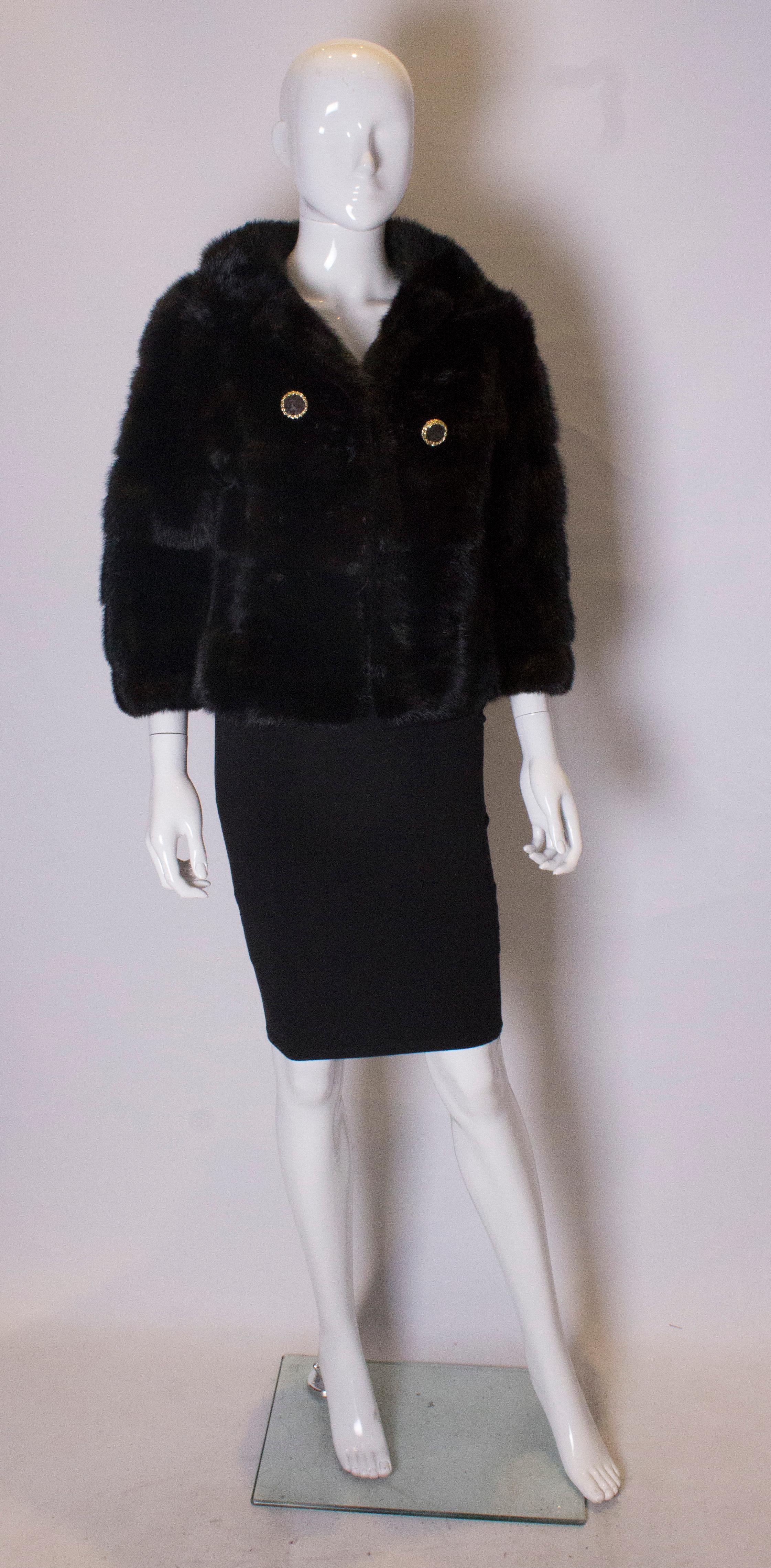 A chic dark mink jacket  with elbow length bracelet sleaves. The jacket has a v neckline and is fully lined. 