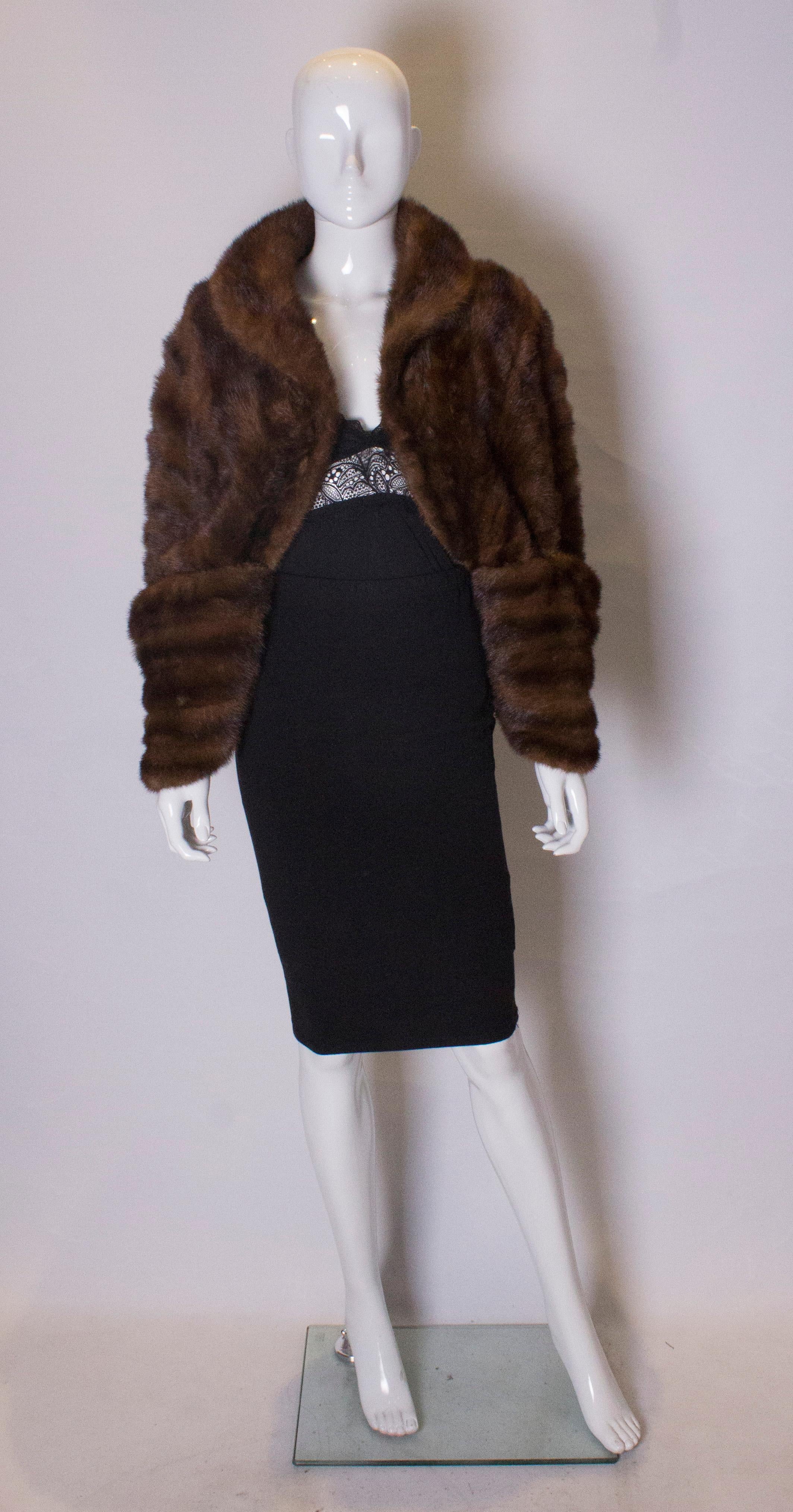 A chic vintage mink shrug with attractive detail on cuffs.  The shrug has a hook fastening, and is fully lined. Measurements. Shoulder to shoulder 24'', length 17''.