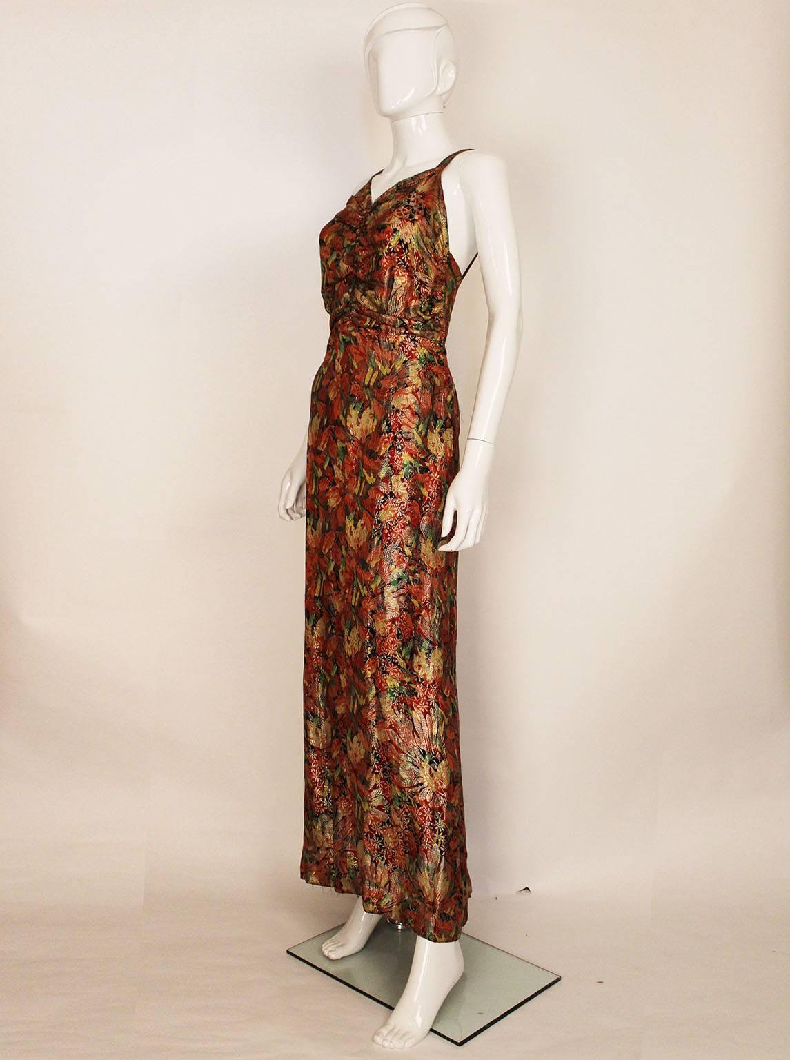 A wonderful head turner,this 1930s gown is colourful and chic.
The colours are a wonderful mix of reds, yellow, green ,gold and black.
The dress has shoulder straps, gathering in the bust, a scoop back,
 and  a central panel at the back that