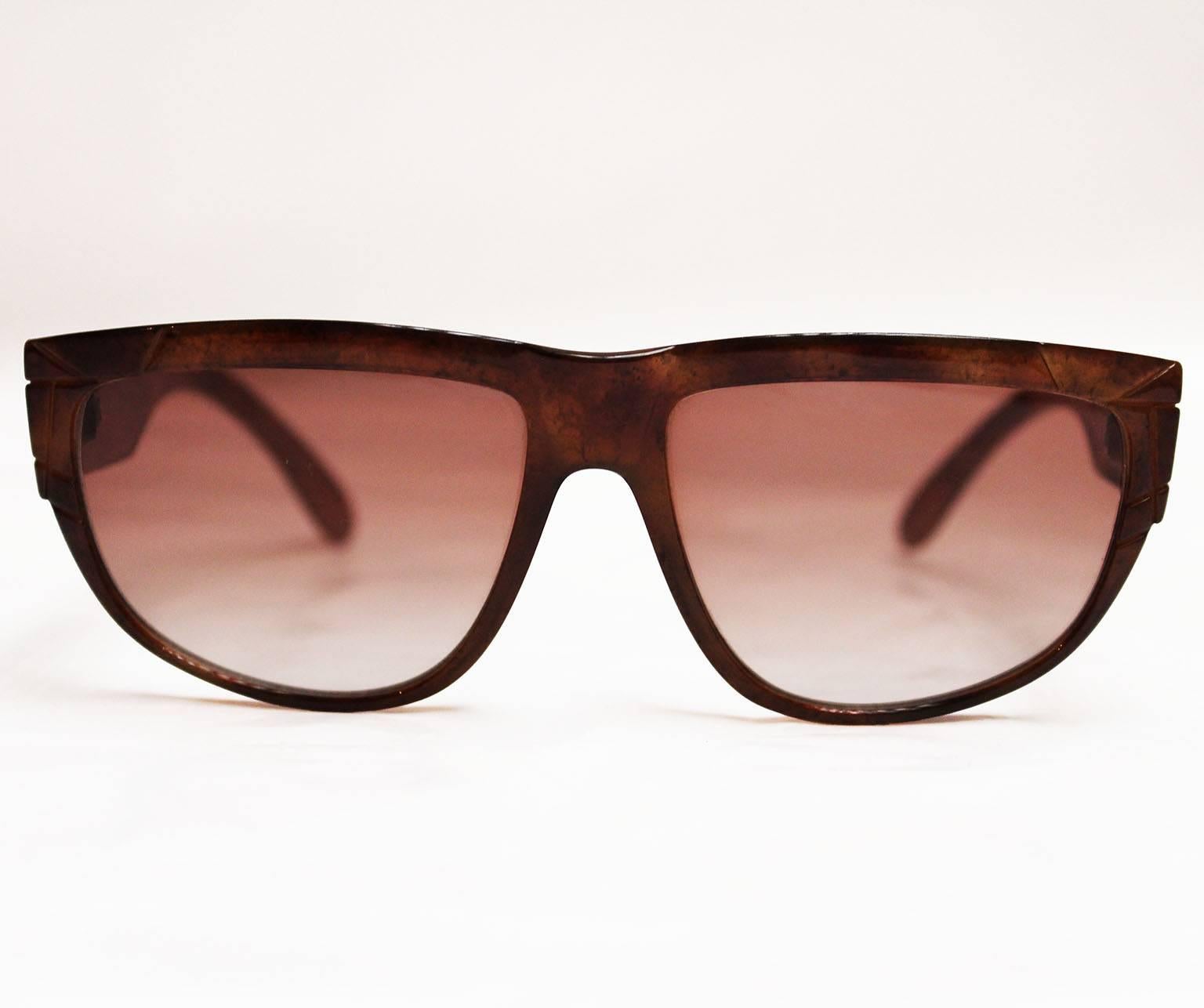 A wonderful pair of Yves Saint Laurent sunglasses,Marrakech -9 Y147. The frames have a brown marble look with geometric molding on each arm.Near the hinge on each arm is a gold YSL logo.
On the inside of the right arm is stamped, YvesSaintLaurent