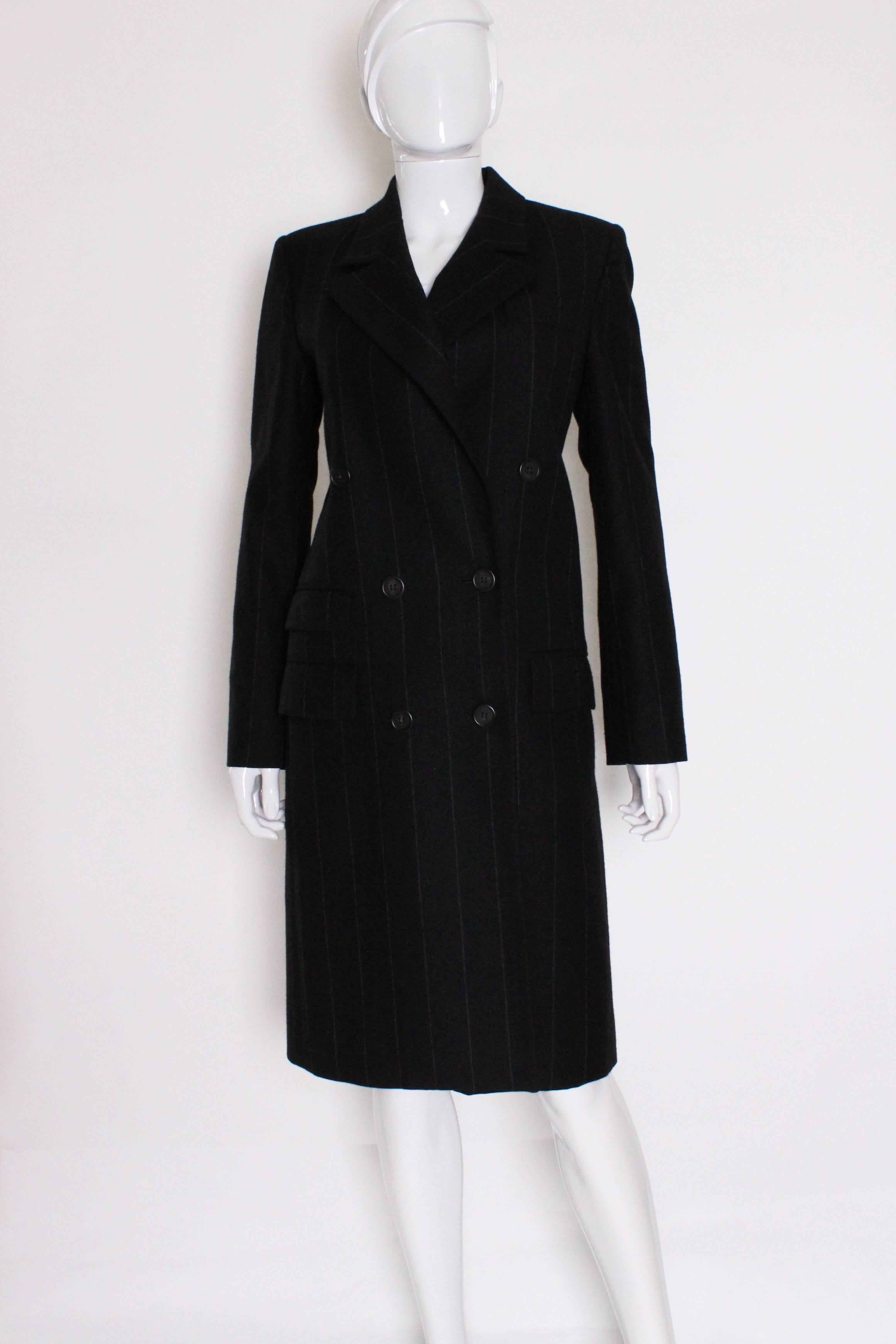 A great  skirt suit for work, or when you feel like dressing for business.
This suit has a double breasted long jacket and matching skirt.
The fabric is a 90% wool, 10% cashmere mix.
The jacket is double breasted and has one pocket on the left