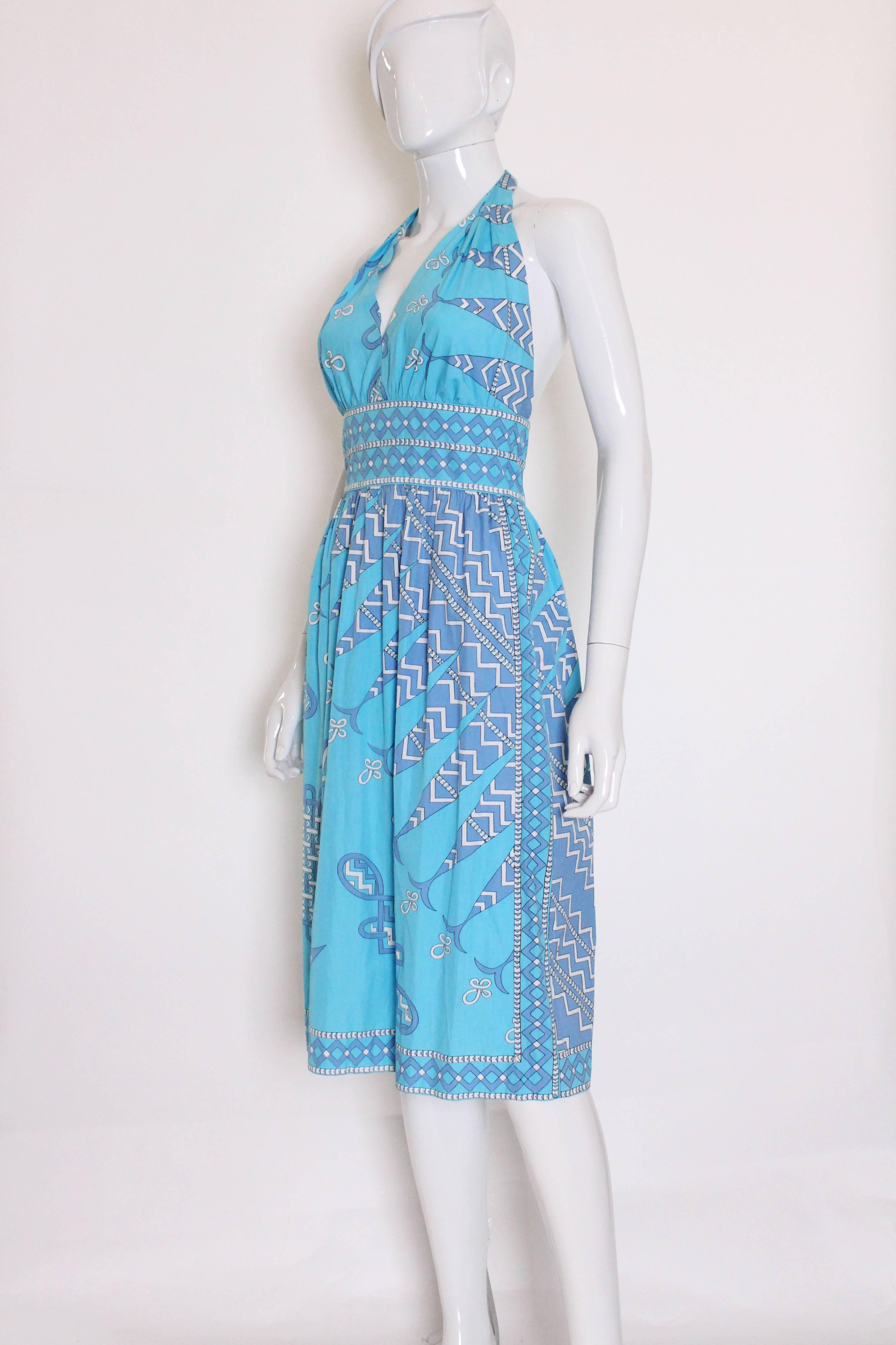 A great dress for summer, this cotton halterneck by Emilio Pucci will turn heads.
The dress was made in Italy by Pucci for the Emilio Pucci Boutique in Saks Fifth Avenue.The background is sky blue and the design is in shades of lilac/blue , black