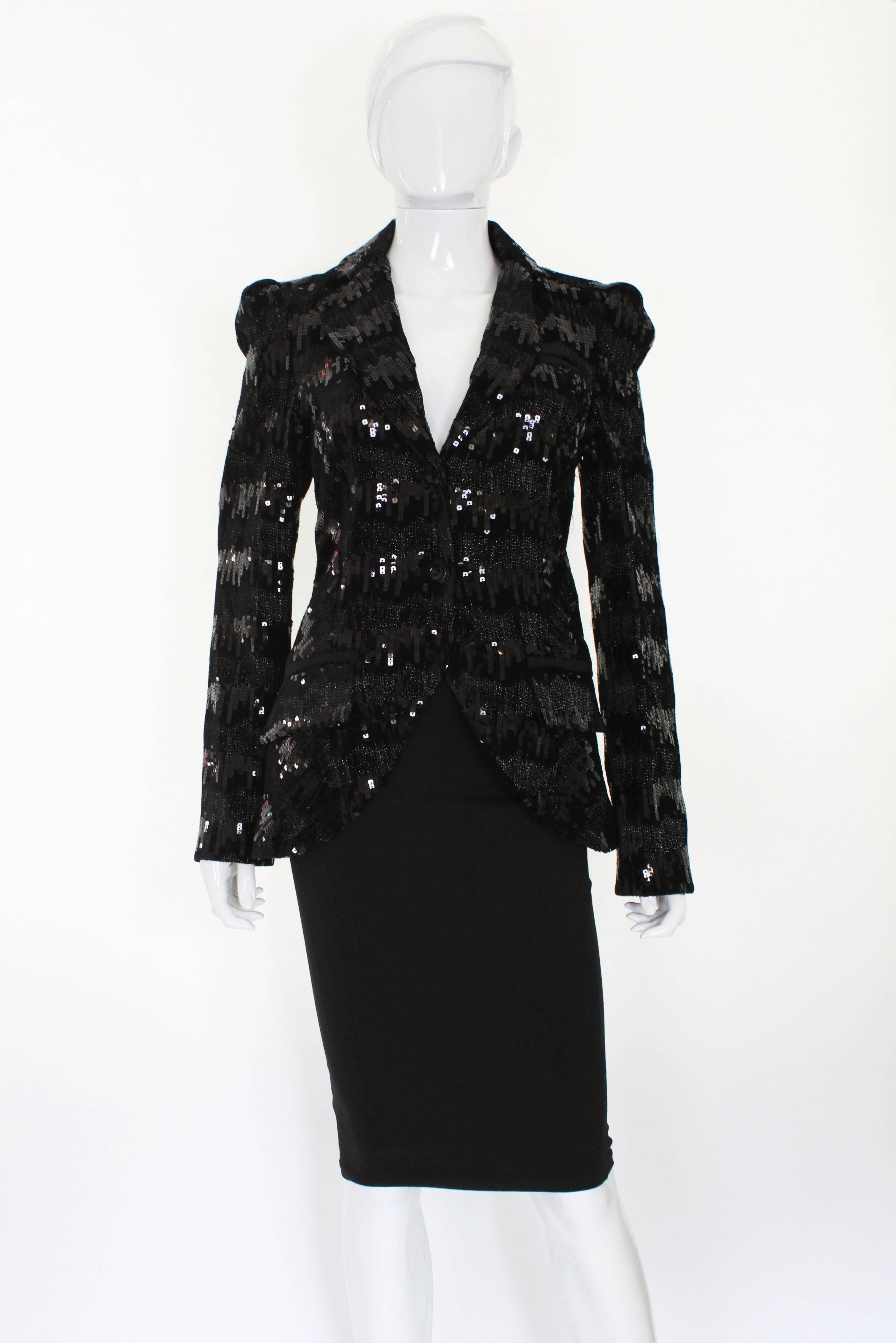 A great jacket by American designer , Diane von Furstenberg.The jacket has bands of sequins on a chenille background. The jacket is lined in silk. There is a fake breast pocket on the left hand side and two fake pockets at hip leval.
There is a 