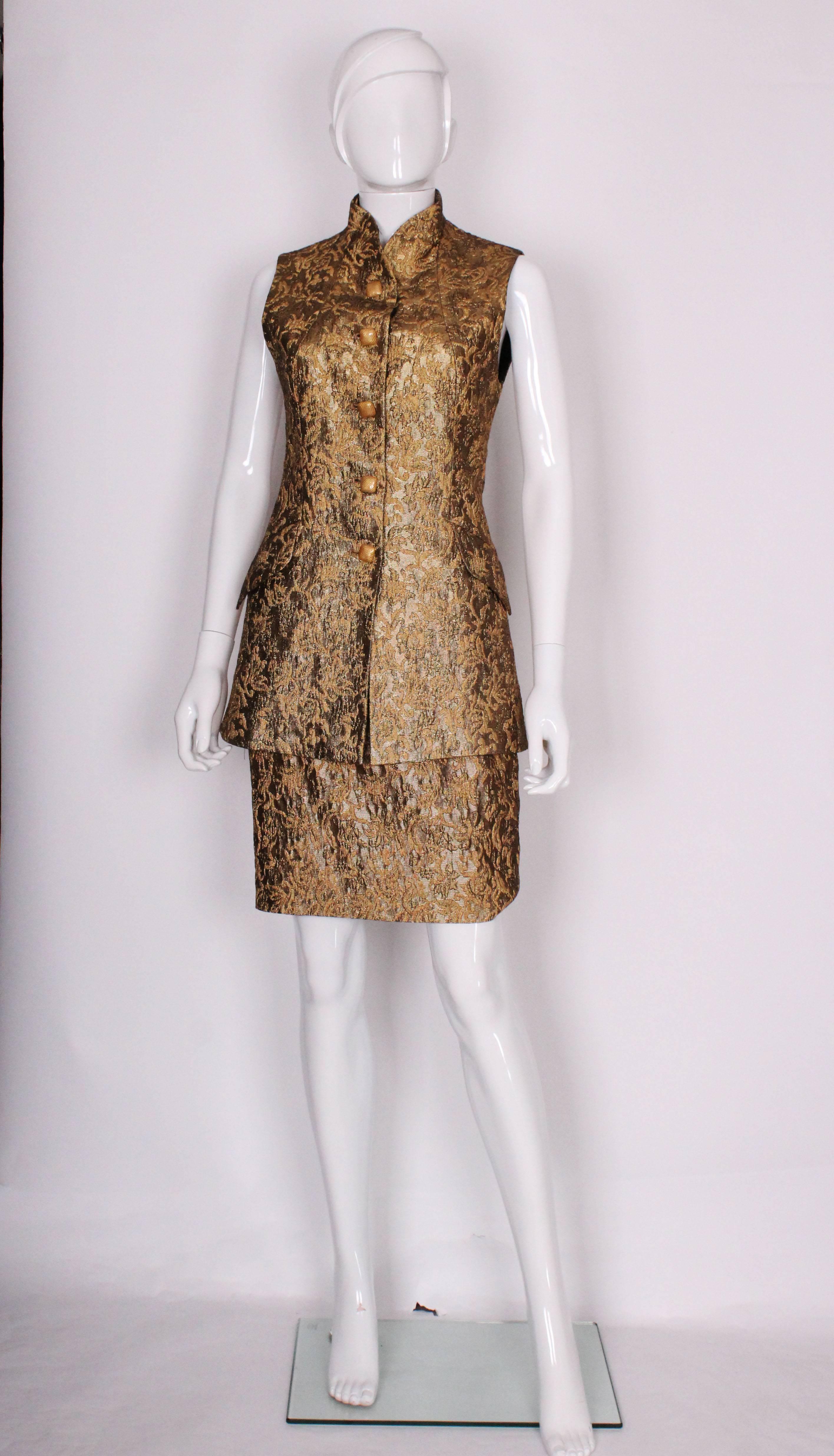 A great evening outfit by British designer Tomasz Starzewski. A chic longline , sleeveles jacket with matching pencil skirt, in a glorious, gold brocade.
The top has a four button opening , and two pockets and measures, bust 33'', length 28''. the