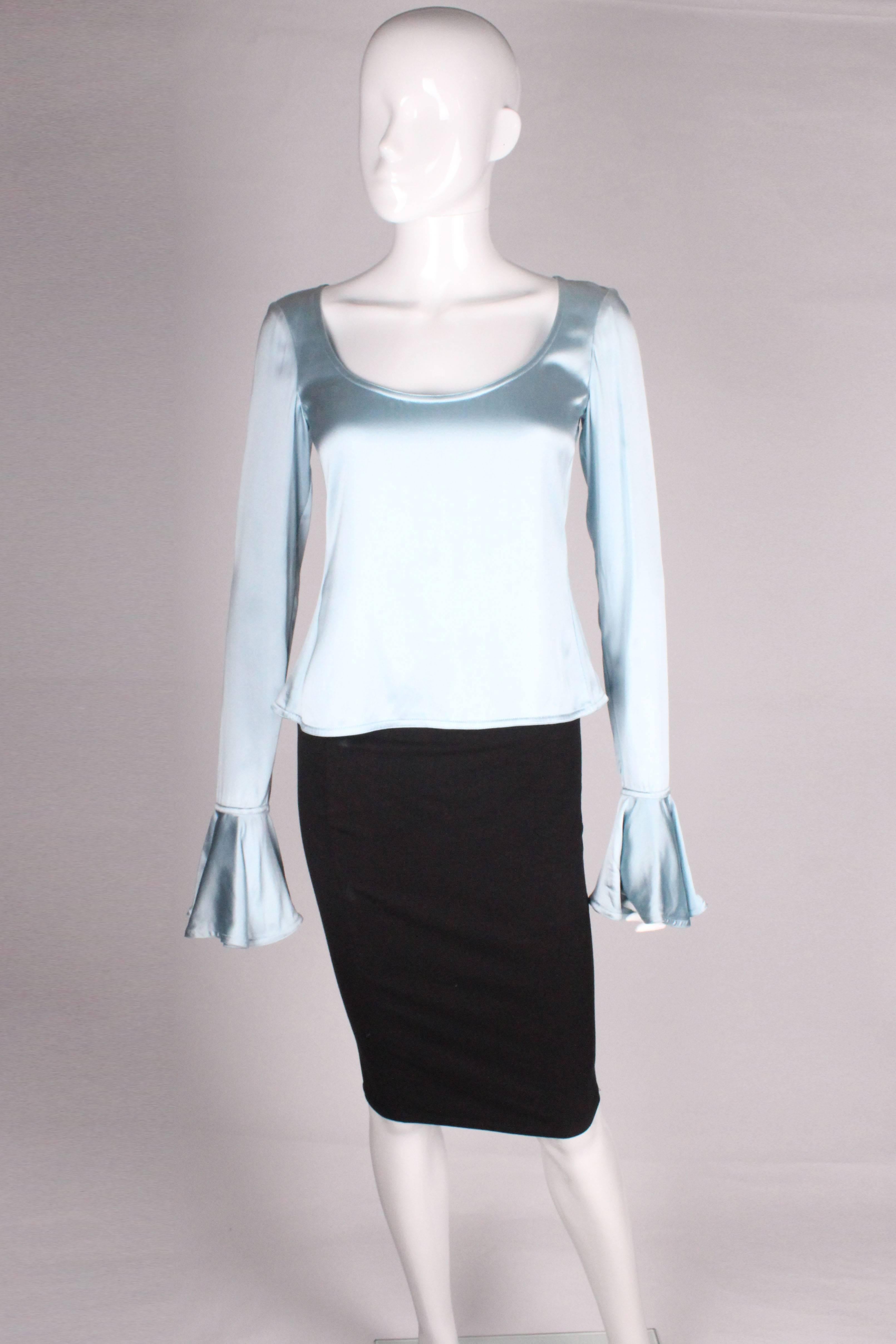 A chic top by French design house, Yves Saint Laurent, Rive Gauche line.
In an ice blue silk , the top has a deep neckline, long sleeves with wonderful frilled cuffs and a central zip opening at the back.