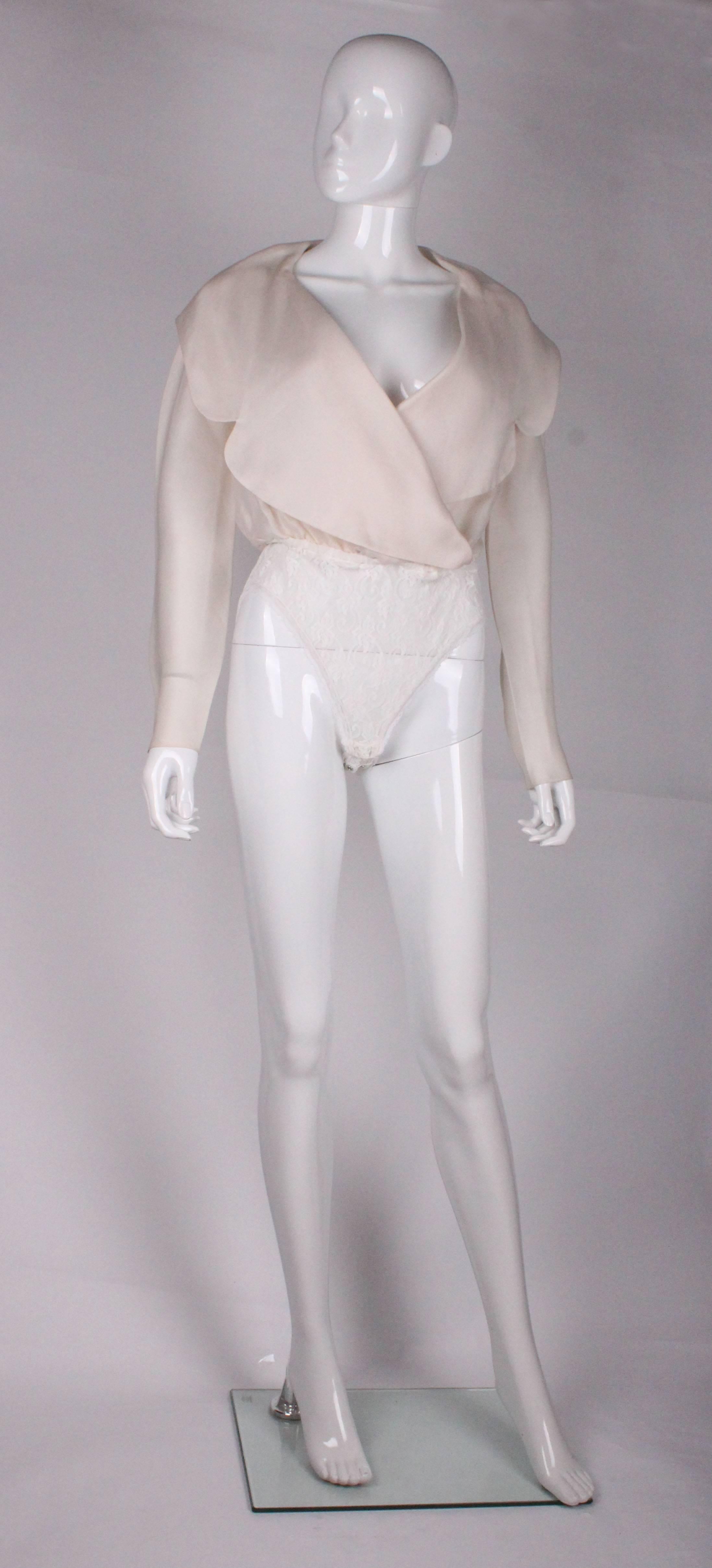 

A great body by Donna Karan. The body part is a lovely ivory silk organza and the pants are lace. The body has an attractive large wrap over collar and long sleeves, and the pants have two rows of two poppers.
Bust 36''shoulder to pants  18''