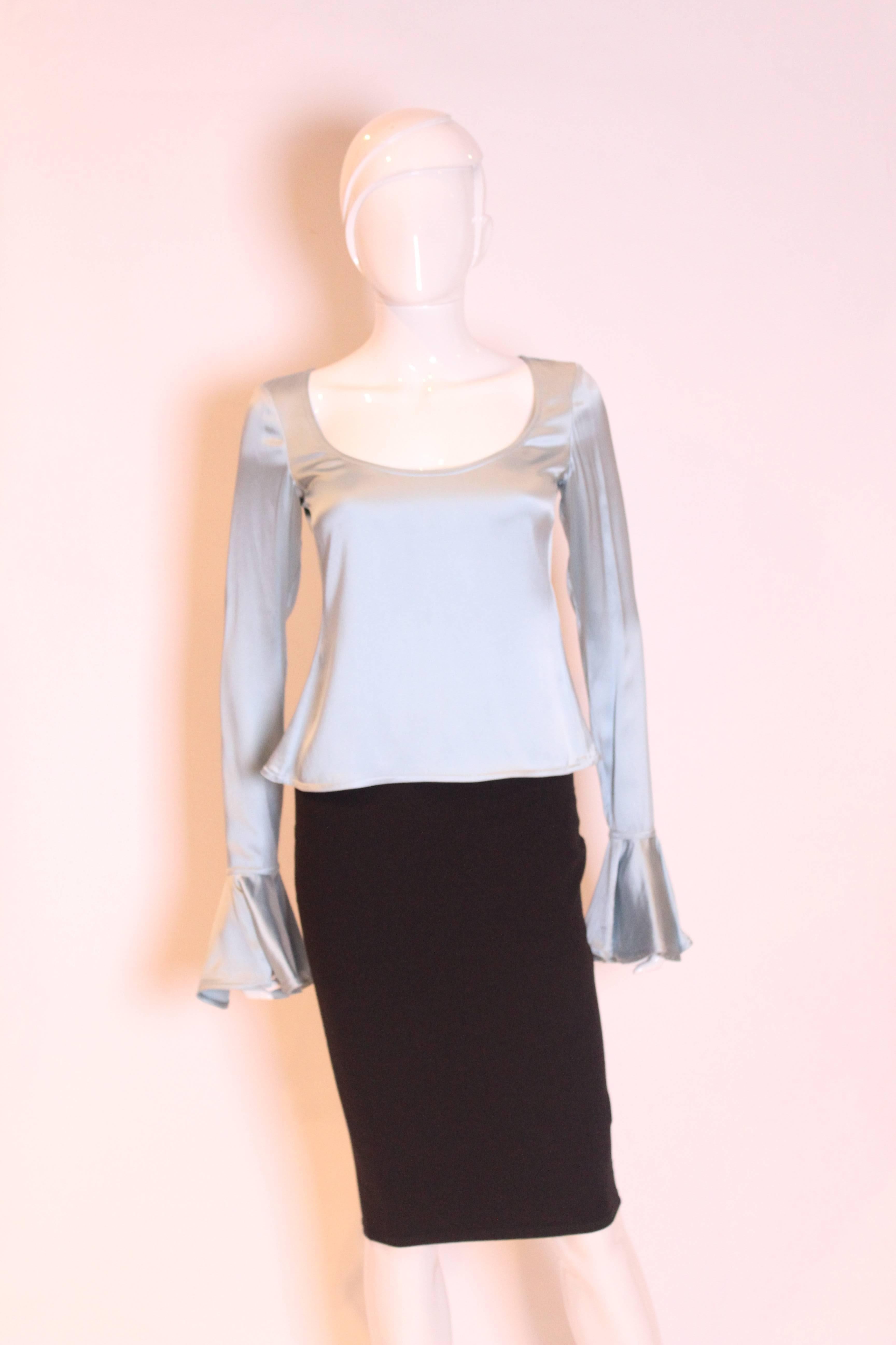 A great top for Spring by Yves Saint Laurent , Rive Gauche.
In an ice blue colour silk, the top has a scoop neckline, long sleeves with a frill cuff and back zip opening.