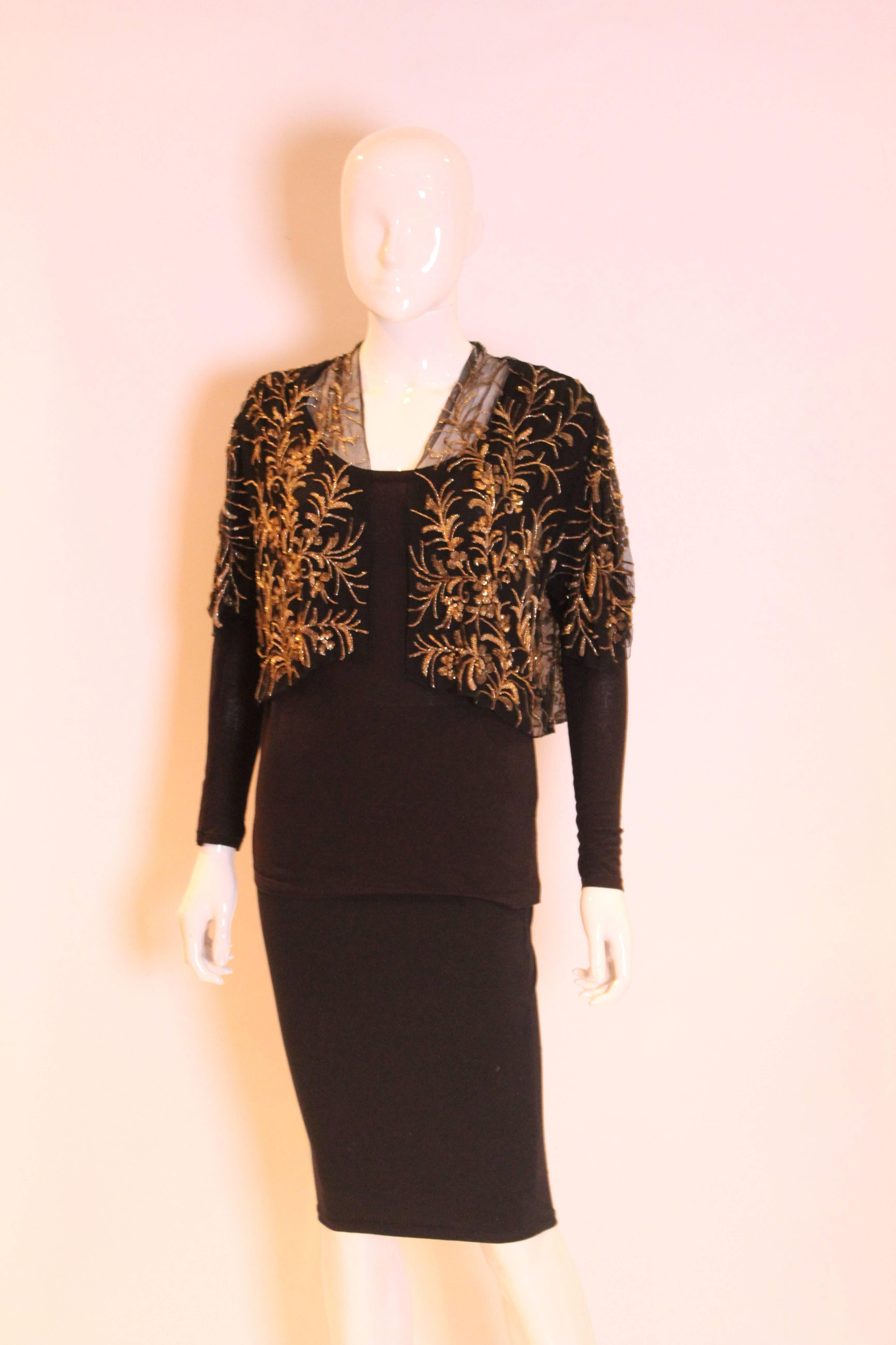 A charming bolero, the base fabric is black  and there is a beautiful soft gold floral design in sequins and beads.The bolero/jacket has short sleeves..The jacket could be lined.