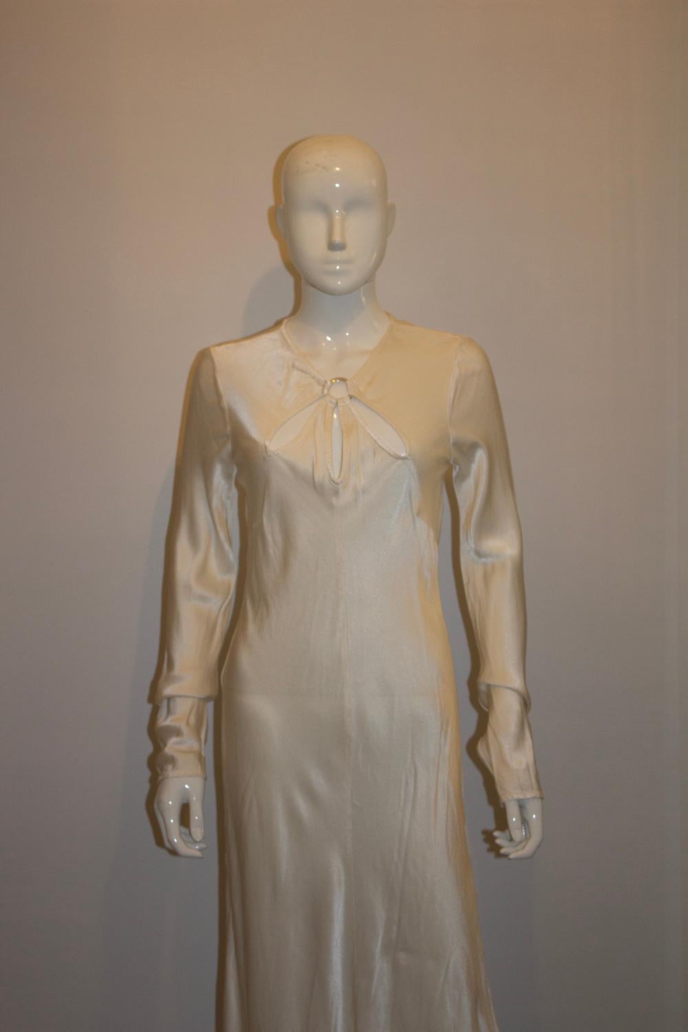 Ein wunderschönes weißes Kleid von Ghost. Wie erwartet ist das Kleid aus einem tollen Stoff, der schön hängt. Es hat eine Knopföffnung auf der Rückseite, mit einem Ring-Detail und Ausschnitten auf der Vorderseite.  Das Kleid hat eine Knopföffnung