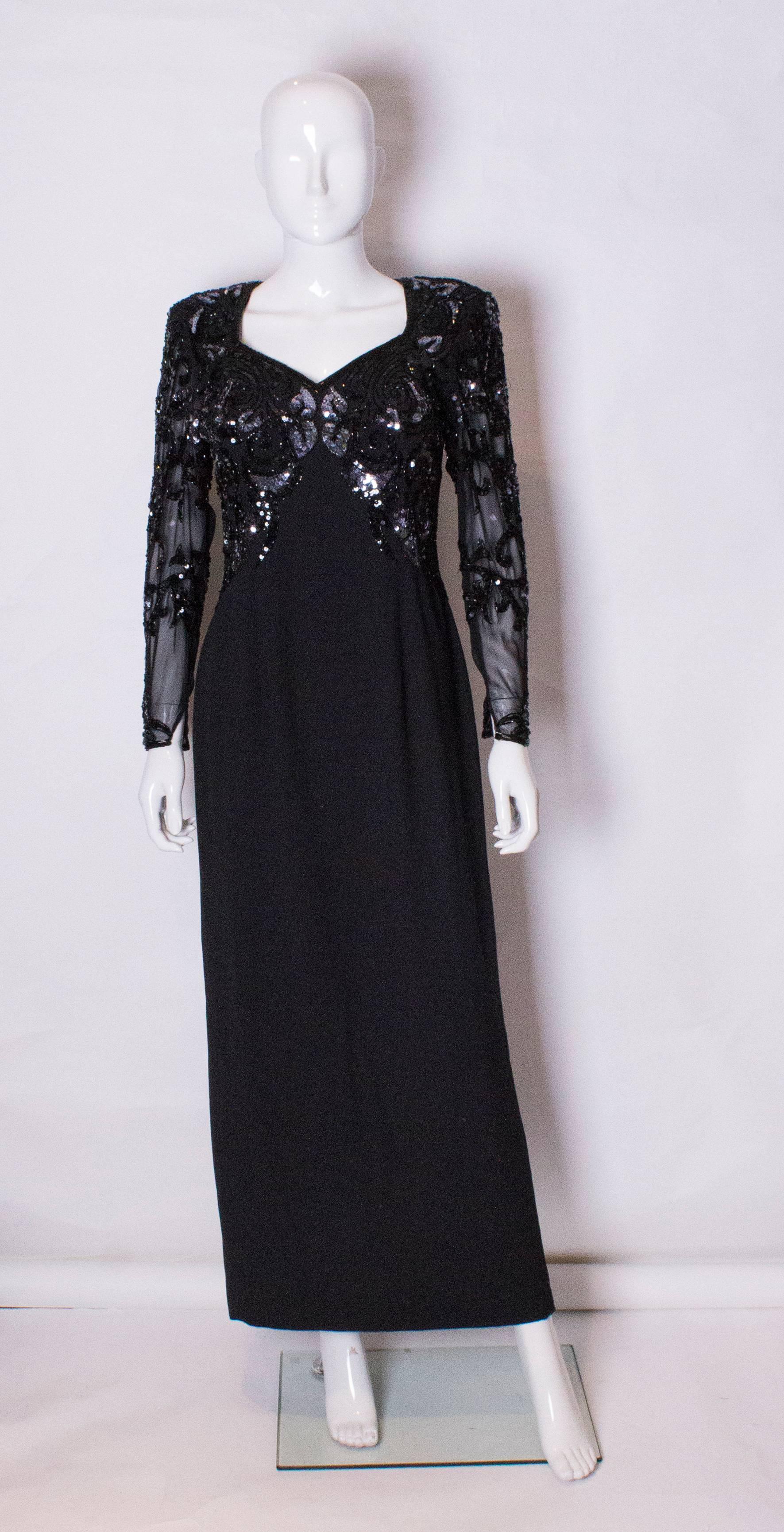 A stunning evening gown by British designer Frank Usher. The dress has a beautifuly beaded bodice on the front and back, and beaded sheer sleeves.
The dress has a central back zip, and a back keyhole opening.
