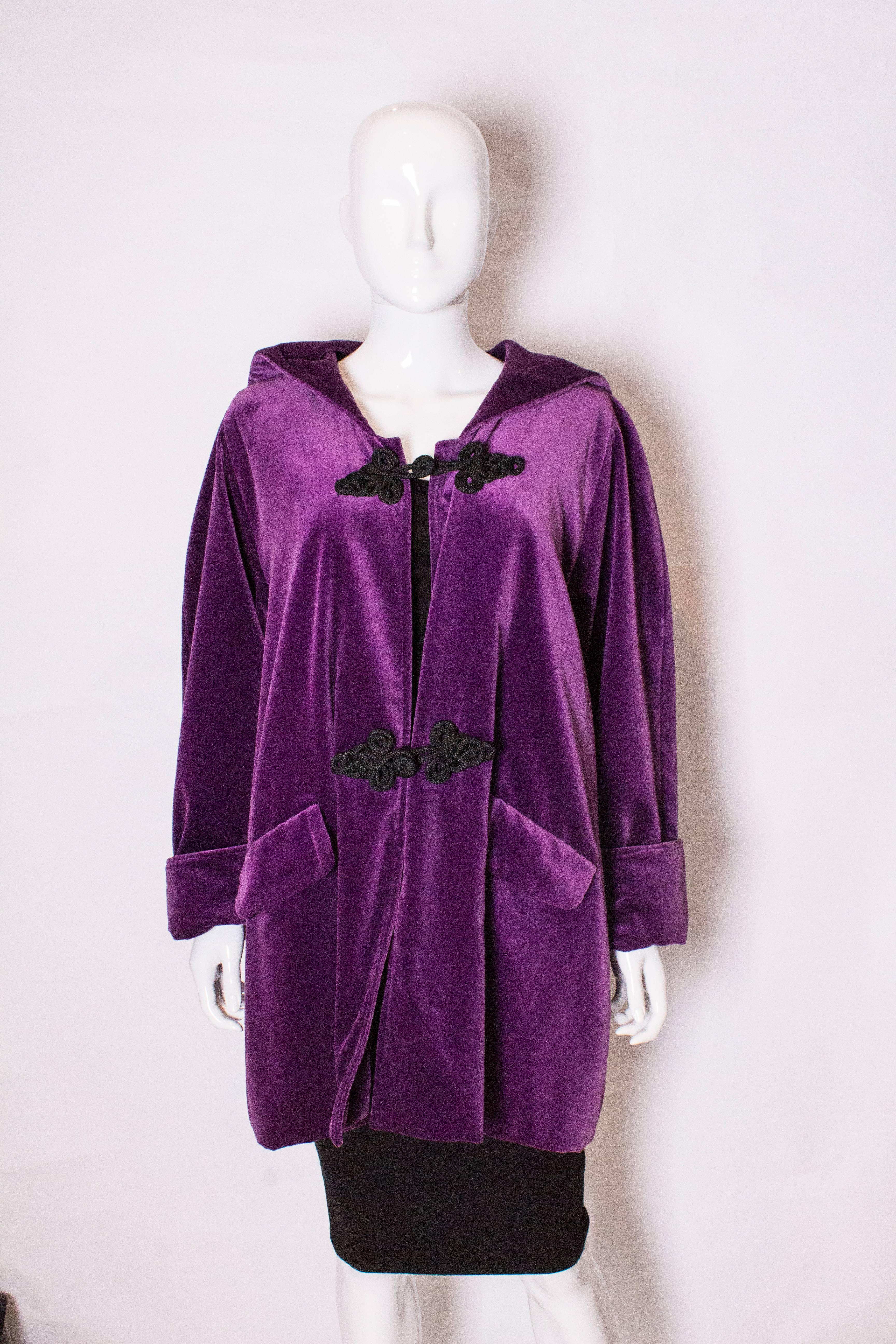 A great , hooded purple velvet jacket by Maribou London. 
The jacket is fully lined and has two pockets at the front and black frogging.