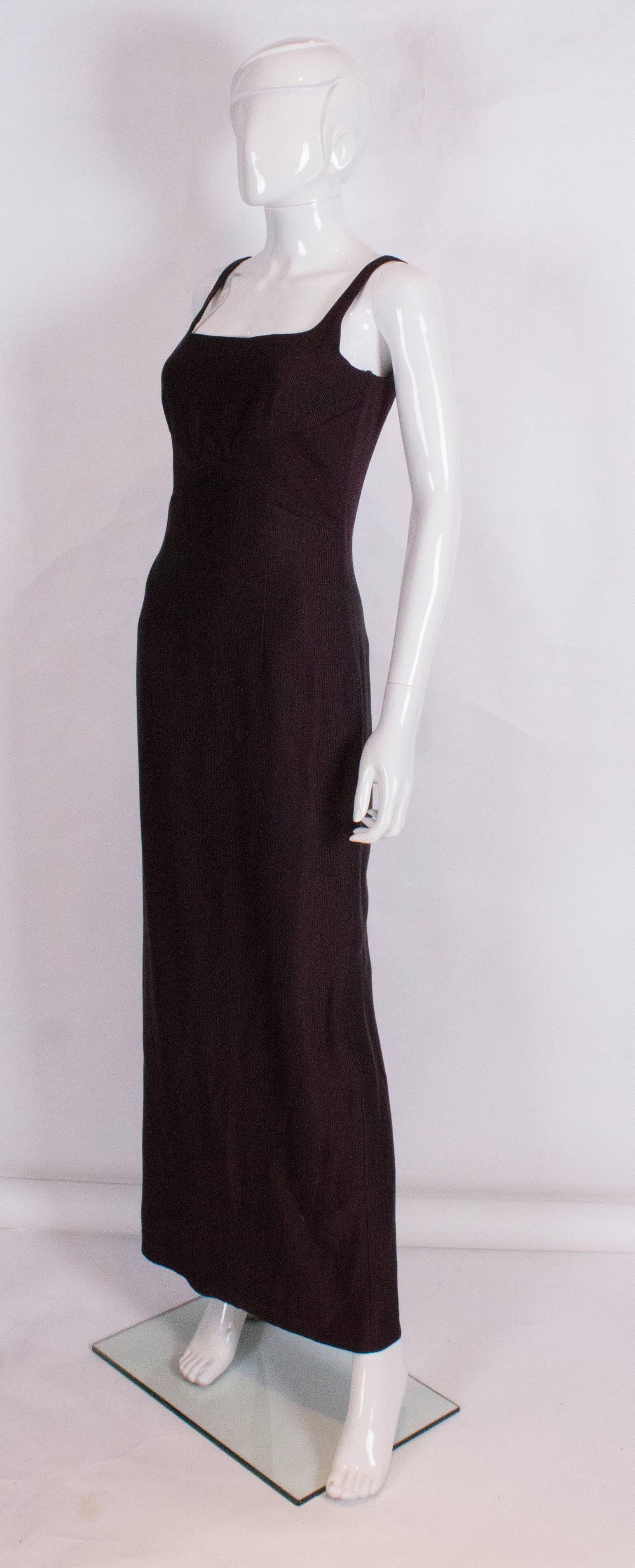 An elegant aubergine colour gown by Maska Luxe .The dress is in a ribbed wool/silk mix fabrc, and has a scoop neckline at the front and back. The dress is fully lined and has a 23'' slit at the back.