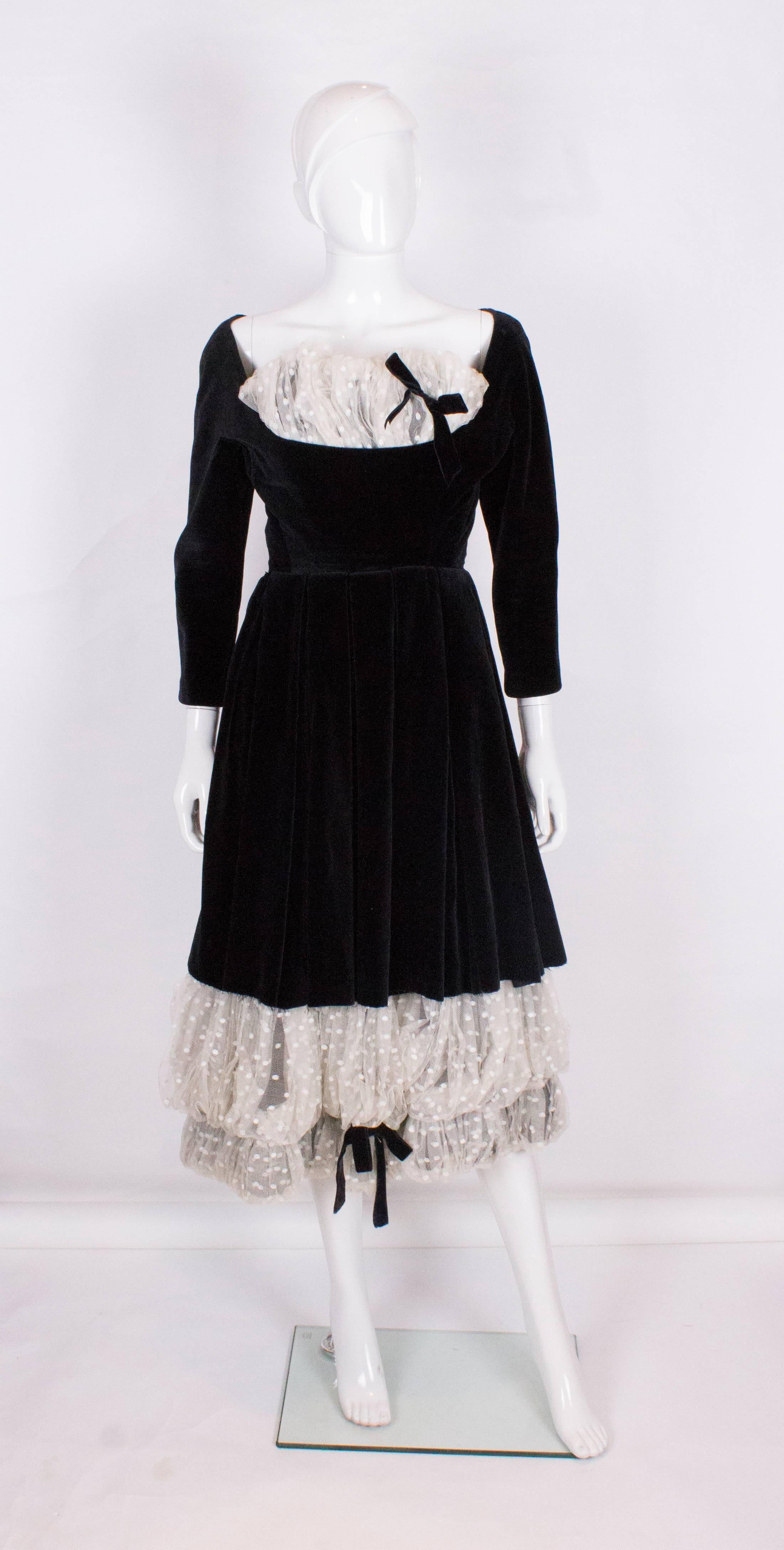 A vintage 1950s Black velvet and lace cocktail dress Very Dior

The dress in a black velvet with a white - grey polka dot lace with velvet trim on hem and a lace ruffle bust detail nipped in waist and three quarter length sleeves 

Almost identical
