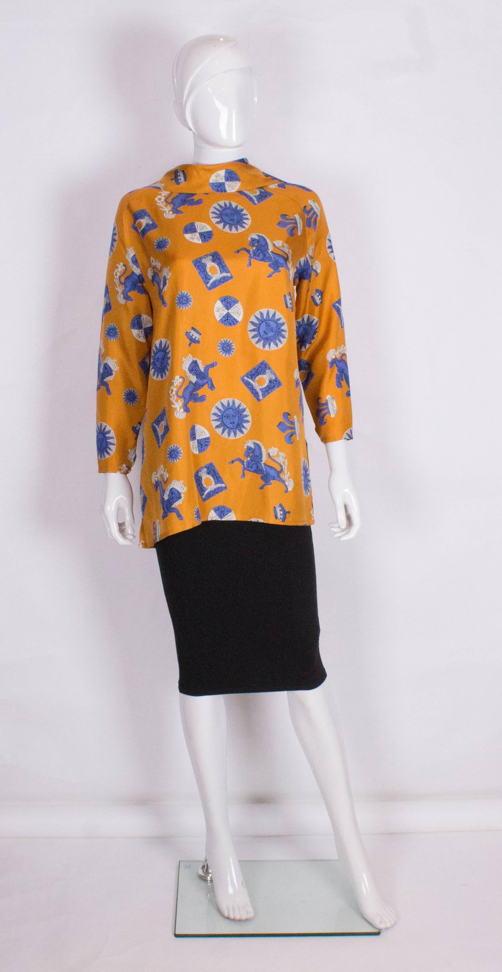 A chic silk tunic by Guy Laroche. The tunic has a 4 button opening at the neck /collar, elbow length sleeves and a 6 1/2 '' slit at either side.