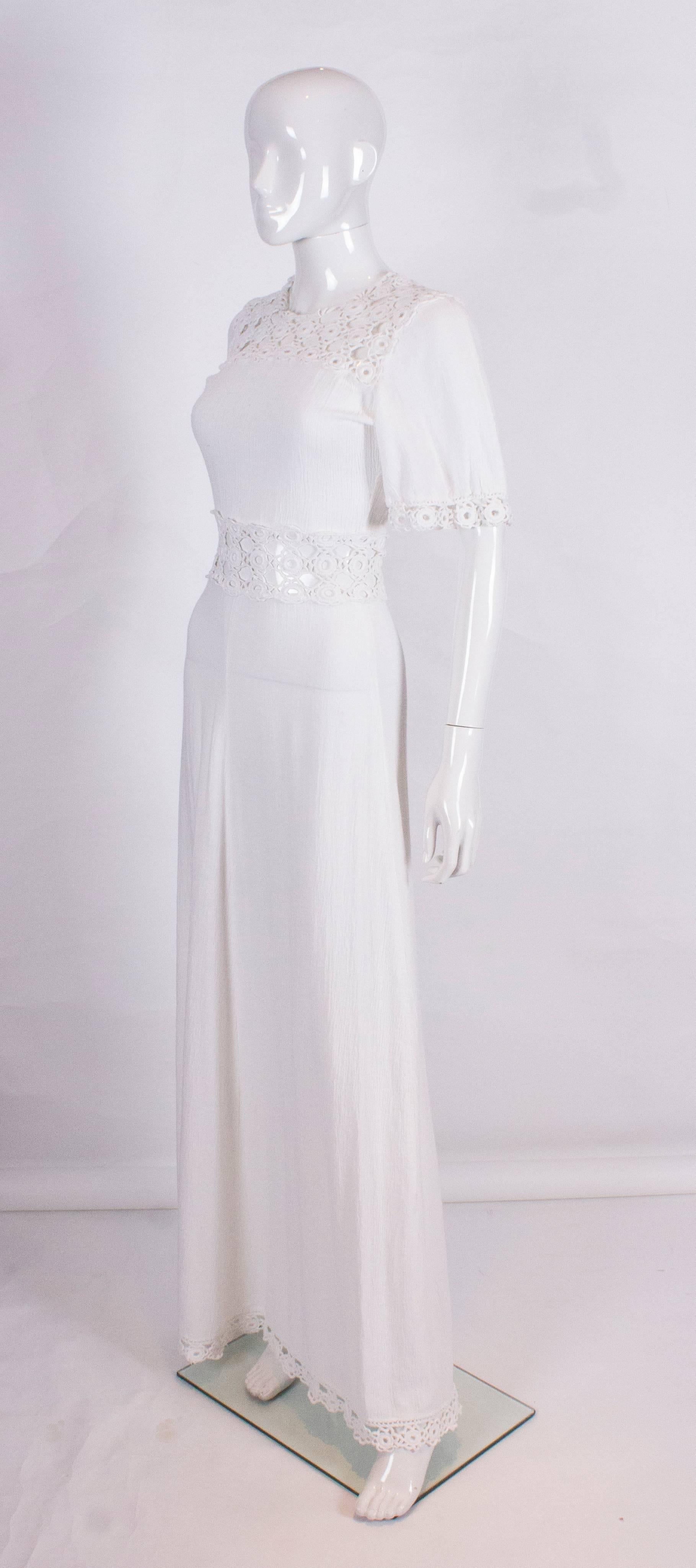 A chic cheesecloth dress with crochet detail. The dress has crochet detail on the yoke, waist, hem and edge of sleeves.