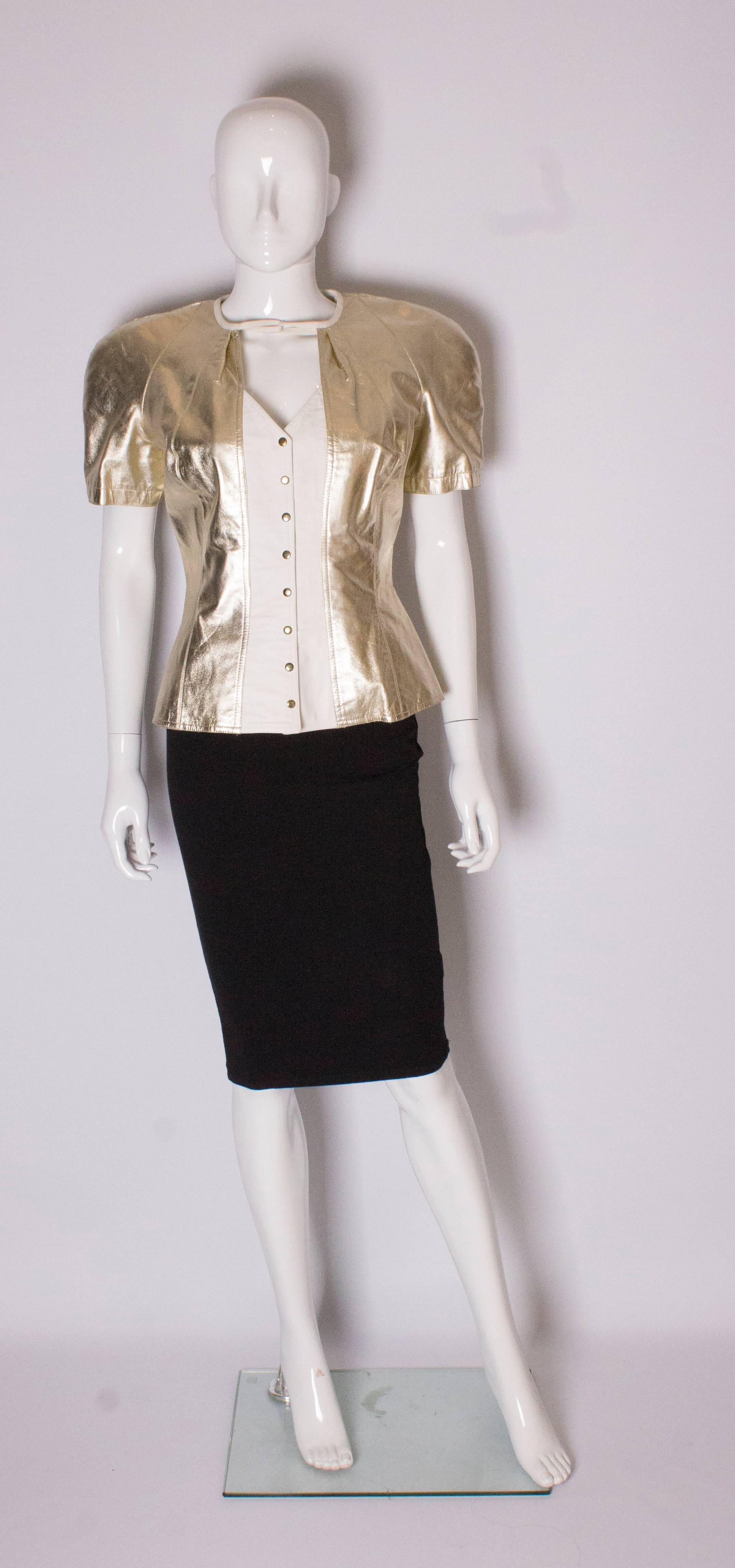 A great addition for the party season. This top /jacket is made of gold and white leather, and is fully lined. The jacket has a v neckline and hook fastenings , with a leather tie at the top of the neck which looks just as good untied or tied. It