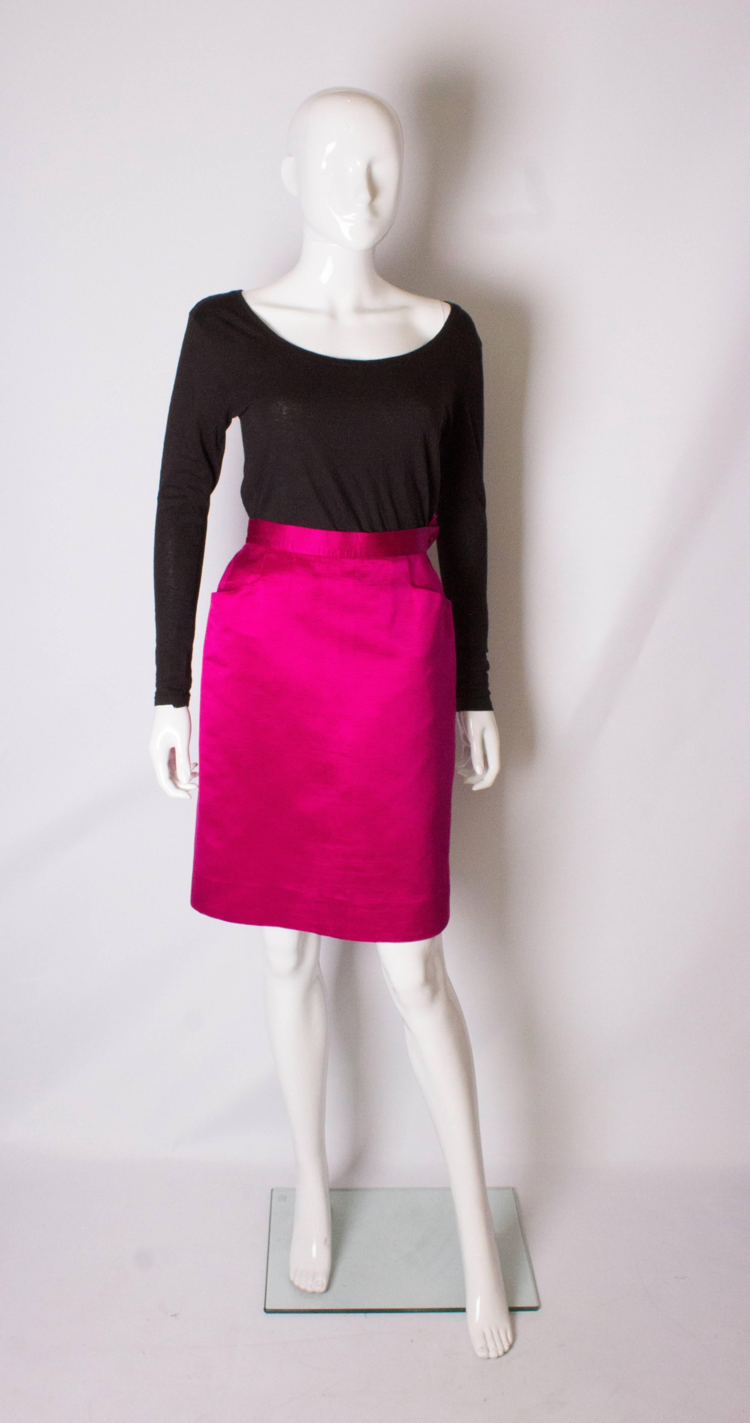 A bright pink skirt,  by Yves Saint Laurent Rive Gauche. The dress has a zip on the left hand side and 2 diagonal pockets. It has been professionally taken in .