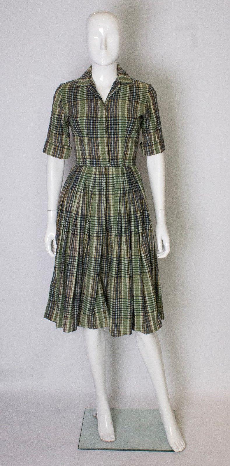 A vintage 1950s gingham striped cotton day dress with a button up front and hocks at the waist 

with a pleated skirt

label - by Neiman Marcus - imported Indian madras

measurements taken flat in inches 

bust -18
waist -12.5
length - 42
 
uk 6