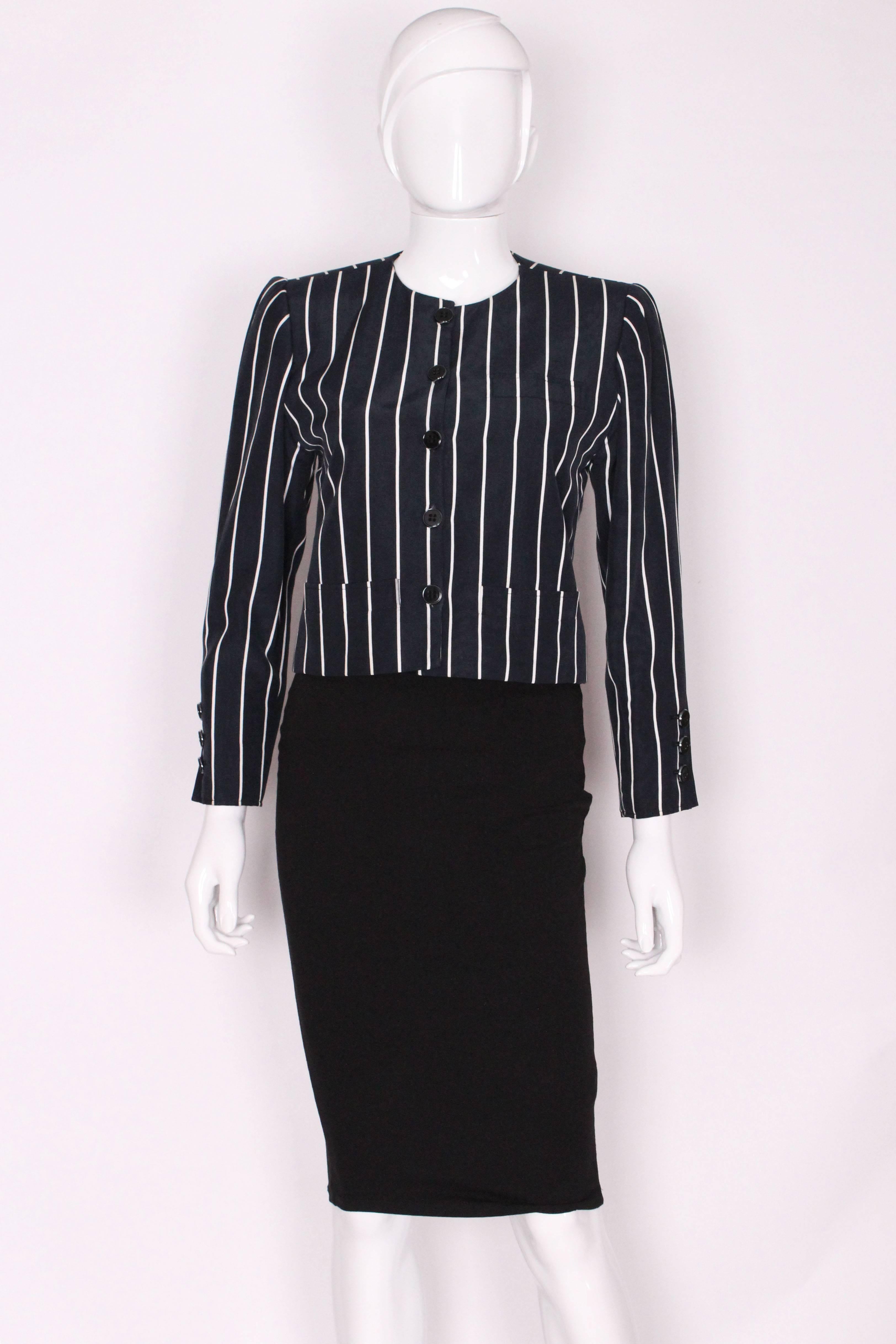 A 1980s but chic , jacket from Yves Saint Laurent, Rive Gauche line.
The jacket is in a dark navy blue with vertical white strips. It has three pockets, one on the left breast and two at waist leval,either side of the central buttons.
It has a five