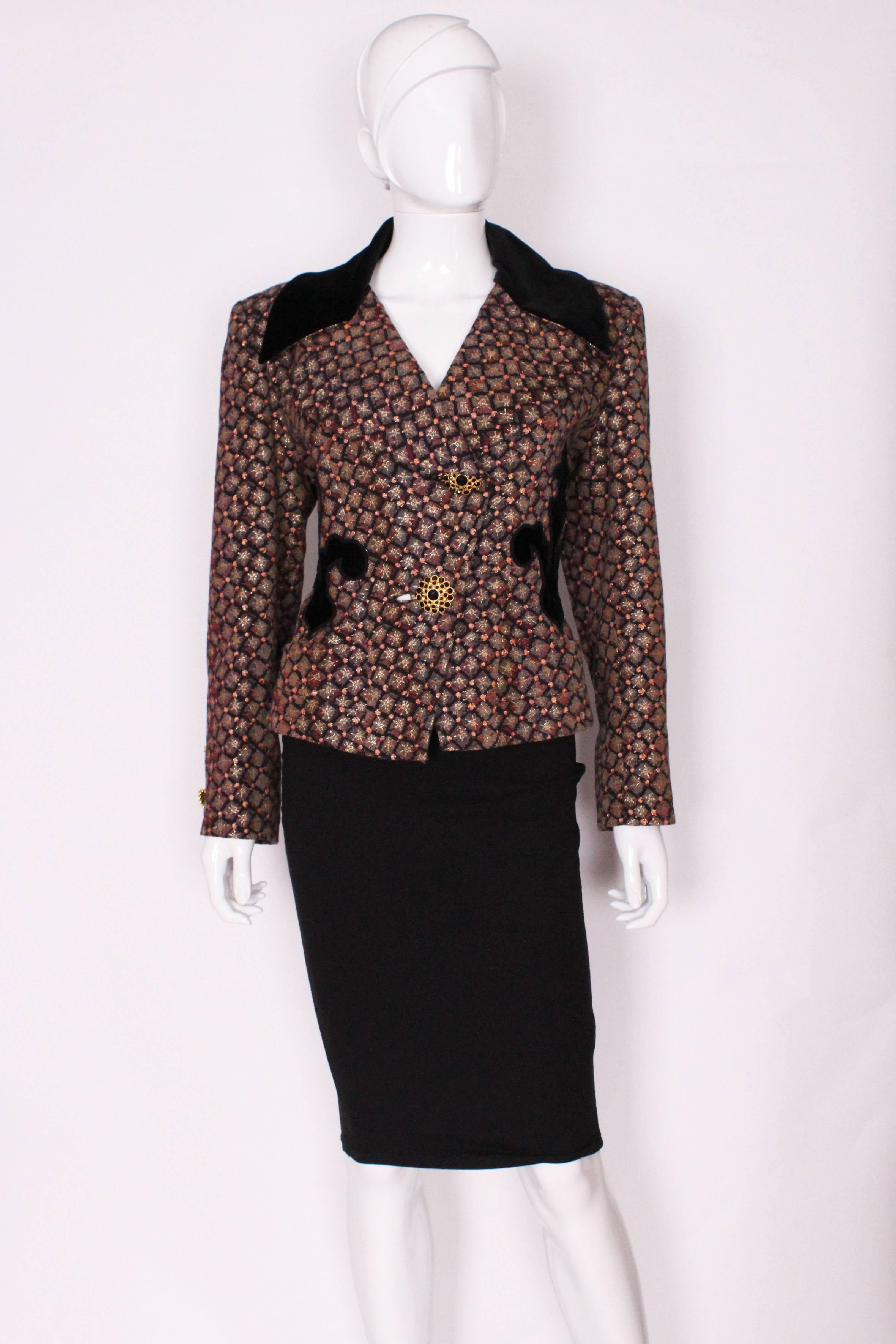 A stunning jacket by French designer Christian Lacroix. In a glorious brocade with velvet collar and detail, plus showstopper buttons. The top part of the collar is black velvet, and there is velvet detail on the front and back. The jacket closes 