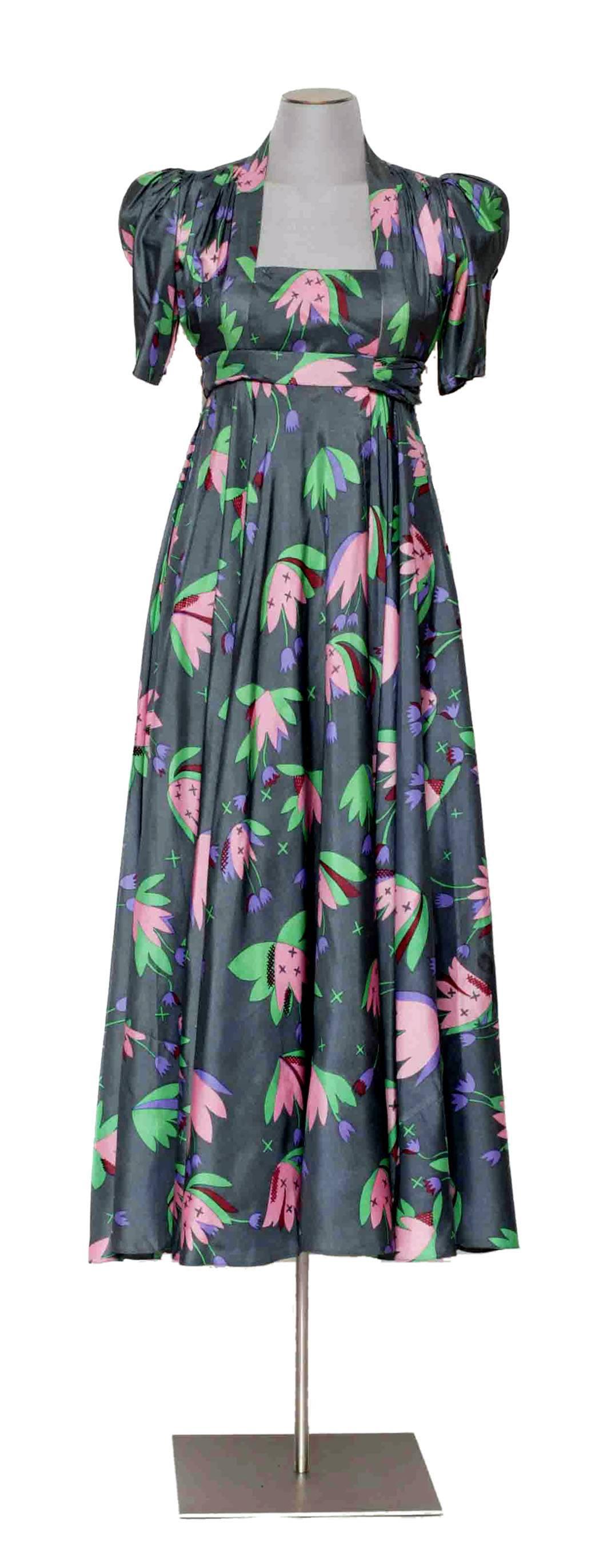 The tulip print wrap dress by Ossie Clark thus not need any introduction, it is one of the most important piece ever made by Ossie Clark in collaboration with Celia Birtwell.
Amazing gray silk ground with whimsical pink & purple tulip print, short
