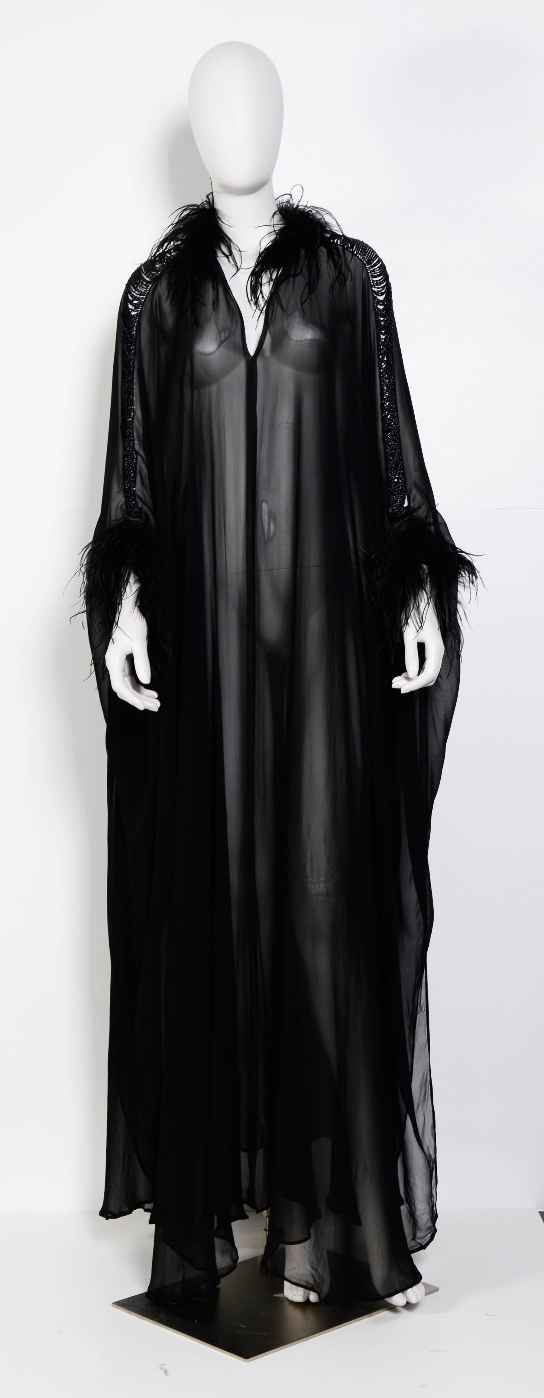 STUNNING!!! 
Rare collectors item by Loris Azzaro. 
Black silk transparent caftan dress. Sleeve with chain detail, feathers around wrist and neck. 
There is no front or back, wear it with or without cleavage.
Excellent condition
Measurements