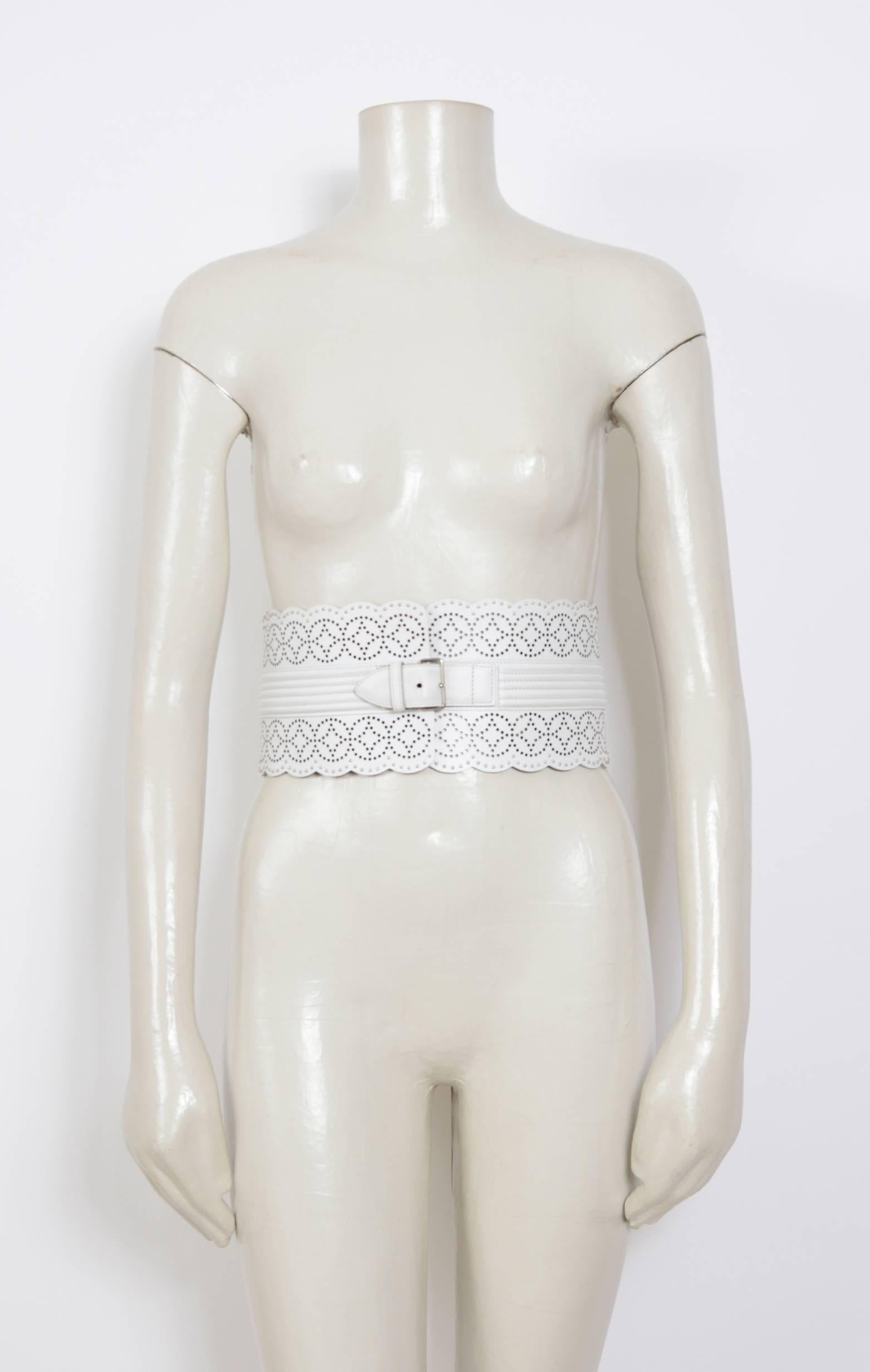 This Alaia belt is composed of white leather with a laser-cut detailing and small metal studs. 
Features a center front adjustable buckle. 
In excellent pre-owned condition, slight signs of wear.
Size 70 