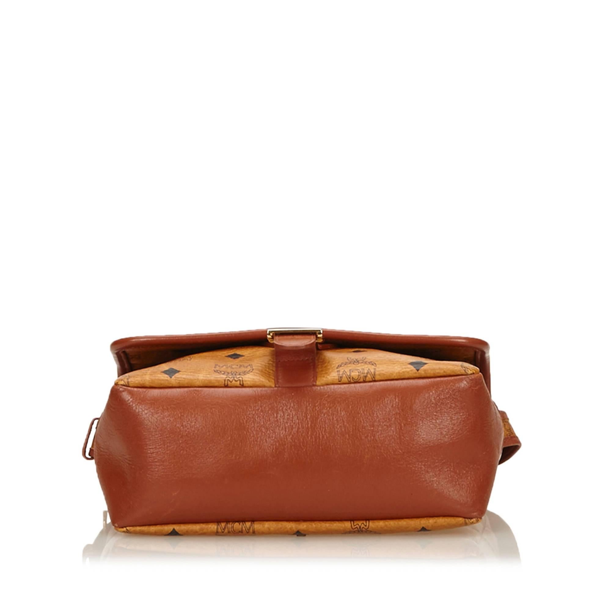 This shoulder bag features a leather body, a flat shoulder strap, a top flap with a belt buckle detail, a top zip closure, and an interior zip pocket.

Color: Brown