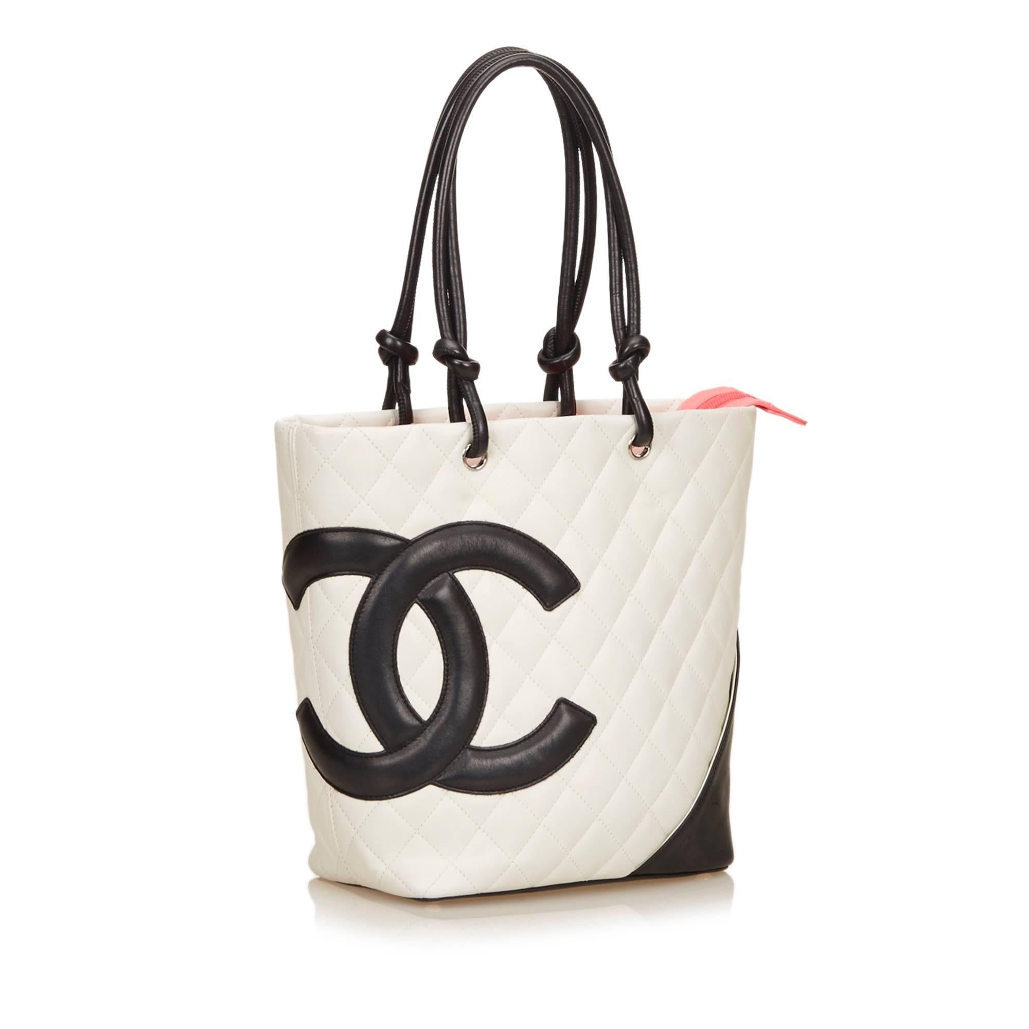 The Cambon Ligne Bucket Tote features a quilted lambskin leather body and interlocking Cs, rolled leather handles, an exterior back slip pocket, a top zip closure, and an interior zip pocket.

Color: Black and White