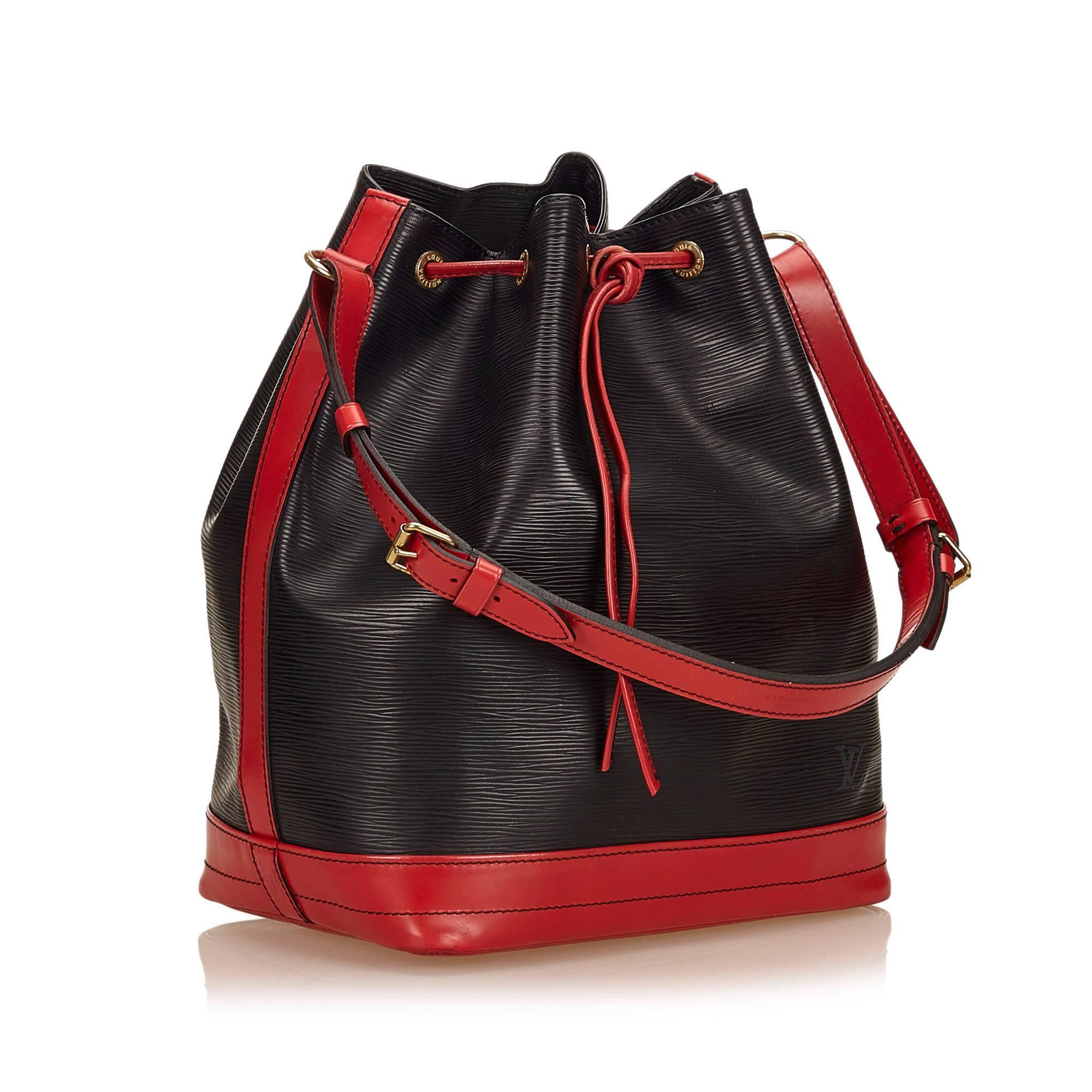 The Noe features a bicolor epi leather body, an adjustable shoulder strap, and a top drawstring closure.

Color: Black and Red 
