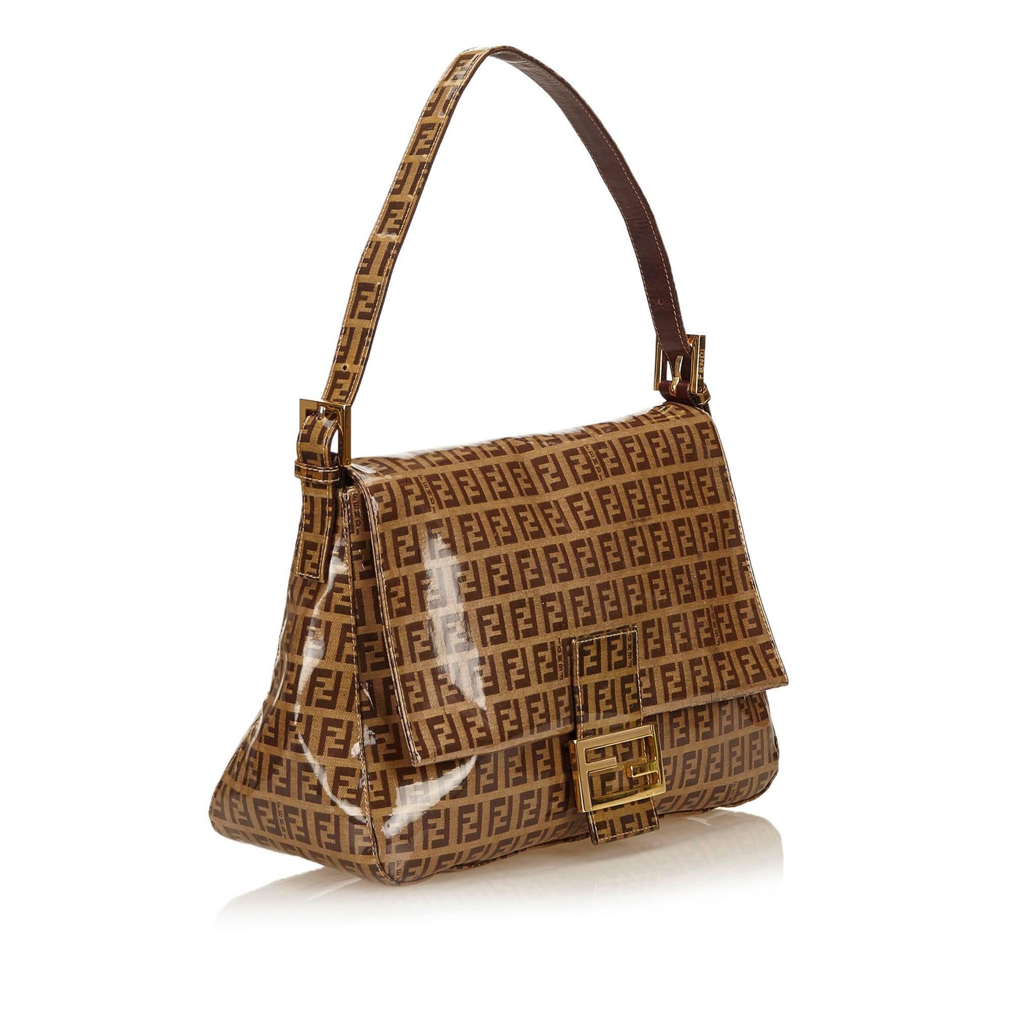 This shoulder bag features a PVC body, a flat leather strap, a front flap with gold-tone hardware, and an interior zip pocket.