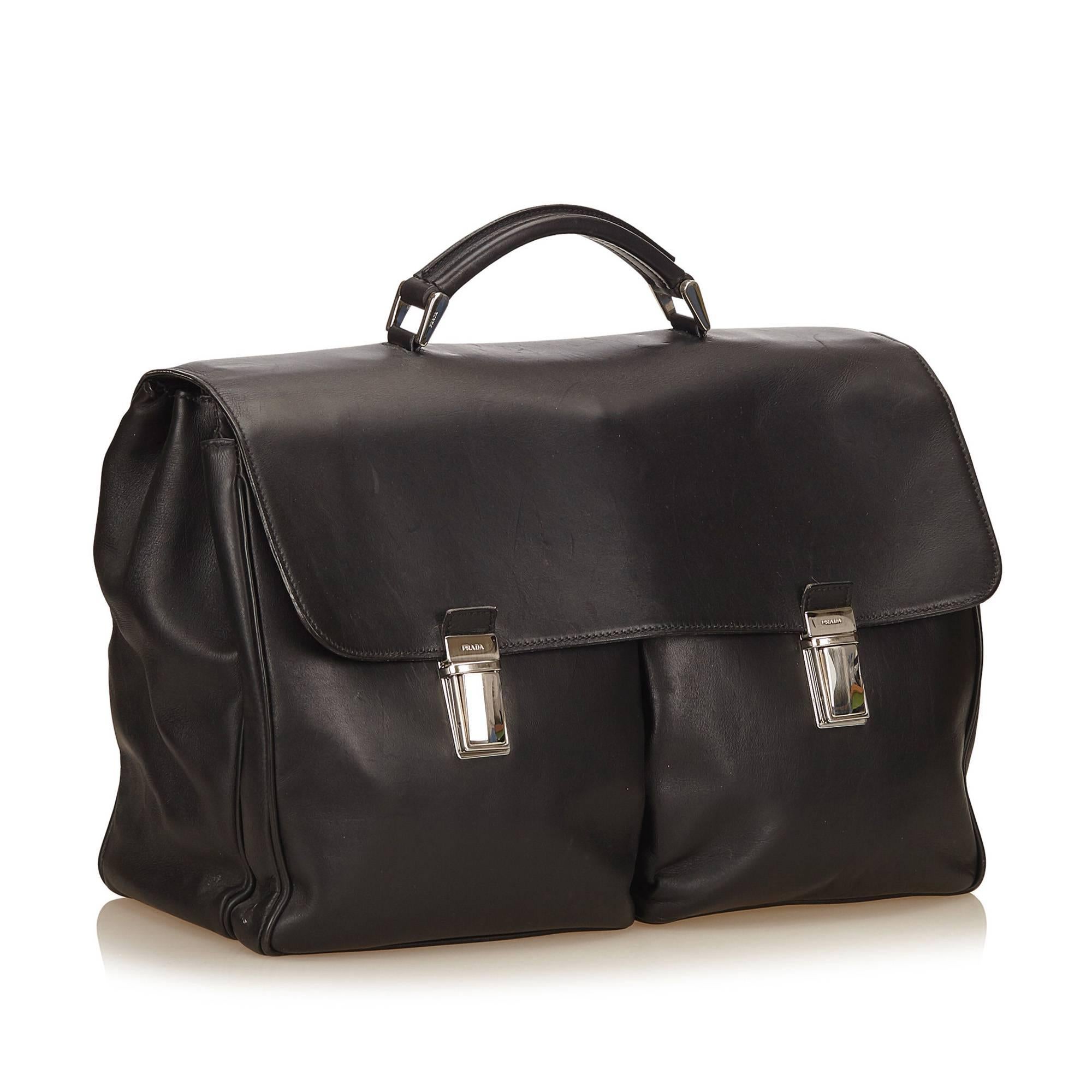 This briefcase features a leather body, exterior back zip pocket, leather handle, front flap with push lock closures, and interior open and zip pockets. 

It carries a B+ condition rating.

Dimensions: 
Length 43 cm
Width 29 cm
Depth 15 cm
Drop 6