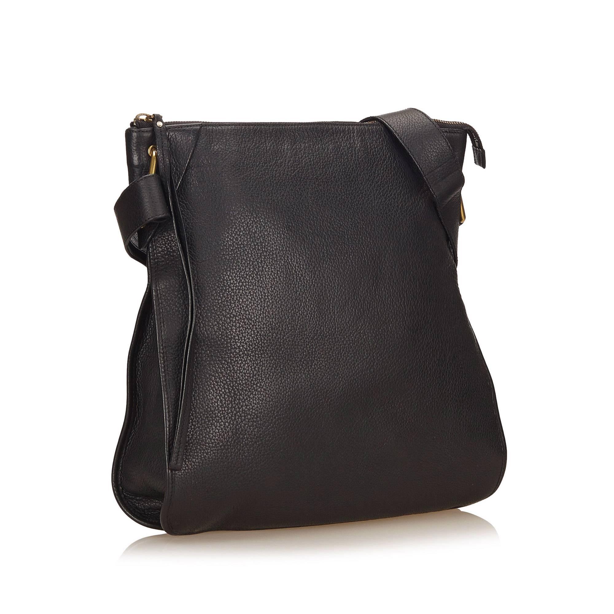 This shoulder bag features a leather body, flat strap, top zip closure, and interior zip pocket. 

It carries a B condition rating.

Dimensions: 
Length 36 cm
Width 40 cm
Depth 5 cm
Shoulder Drop 61 cm

Inclusions: No longer comes with original