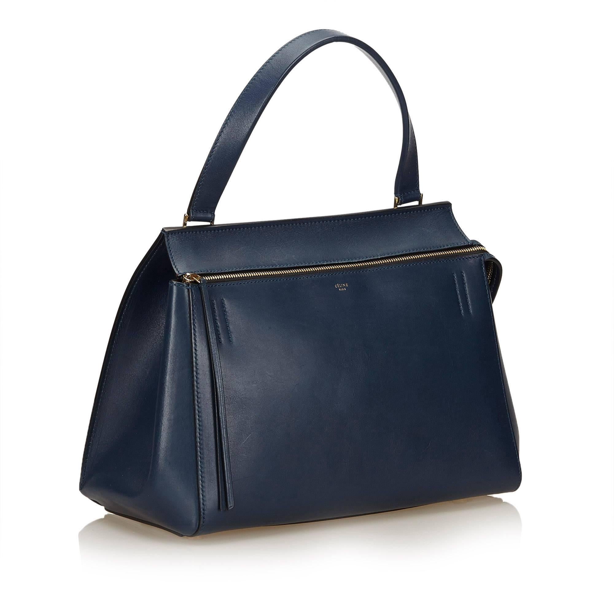 The Large Edge Bag features a leather body, exterior front zip pocket, back slip pocket, flat leather handles, top zip closure, and interior slip pockets. 

It carries a B+ condition rating.

Dimensions: 
Length 27 cm
Width 36 cm
Depth 18 cm
Hand