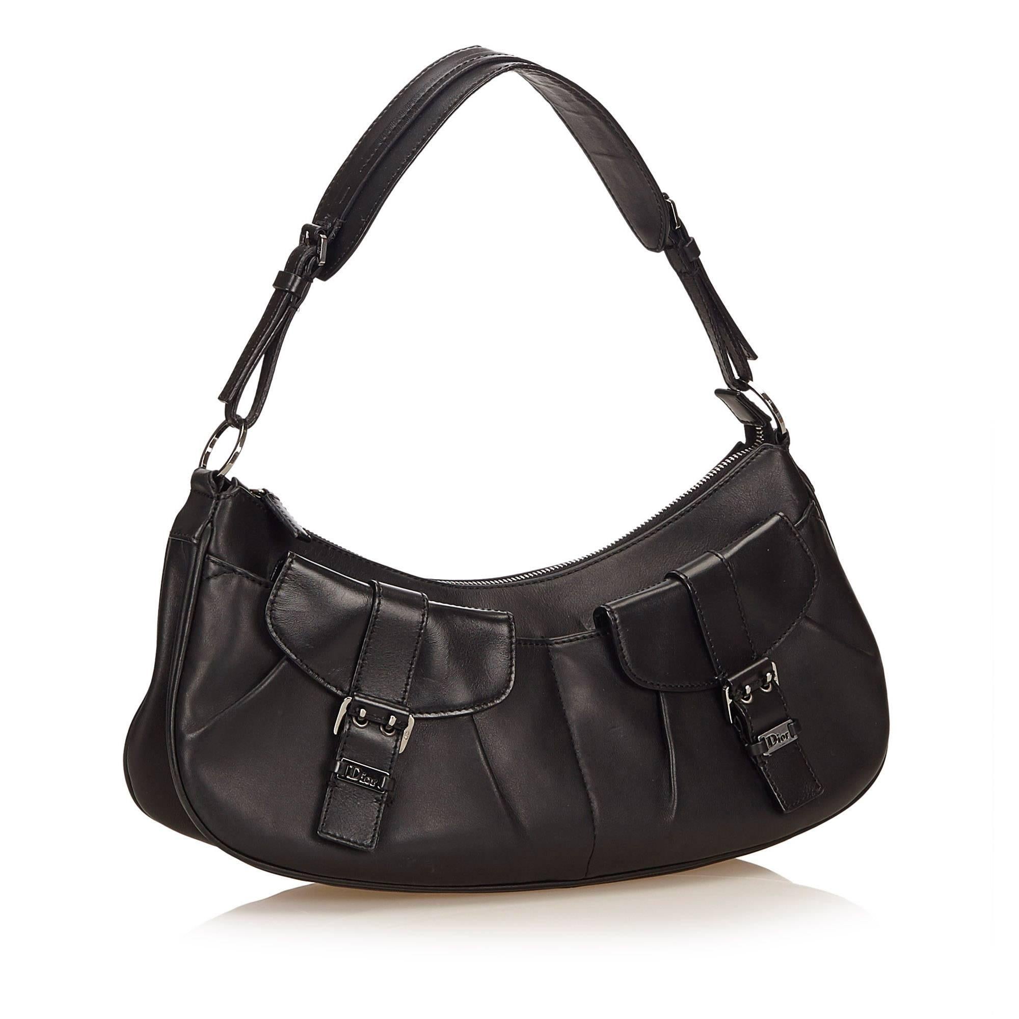 This shoulder bag features a leather body, flat strap, top zip closure, and interior zip pocket. 

It carries a B condition rating.

Dimensions: 
Length 35 cm
Width 15 cm
Depth 9 cm
Shoulder Drop 22 cm 

Inclusions: No longer comes with original