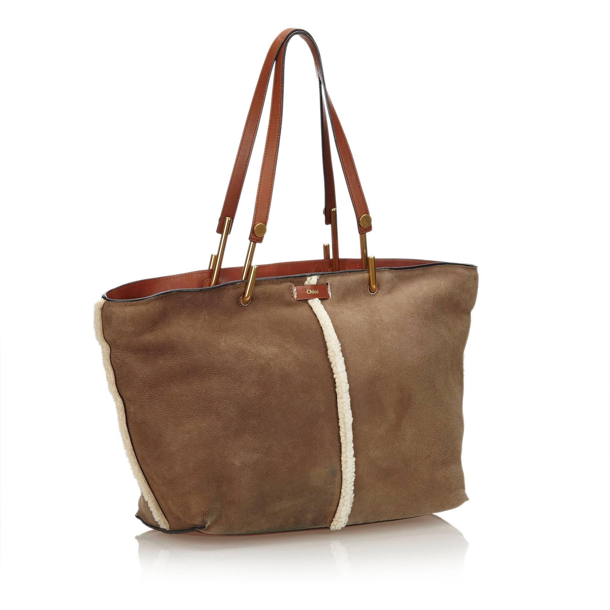 This Keri tote bag features a leather body with mouton trim, flat leather straps, top zip closure, and interior zip pocket. 

It carries a B condition rating. 

Dimensions: 
Length 35 cm
Width 26 cm
Depth 12 cm
Shoulder Drop 25 cm

Inclusions: Dust