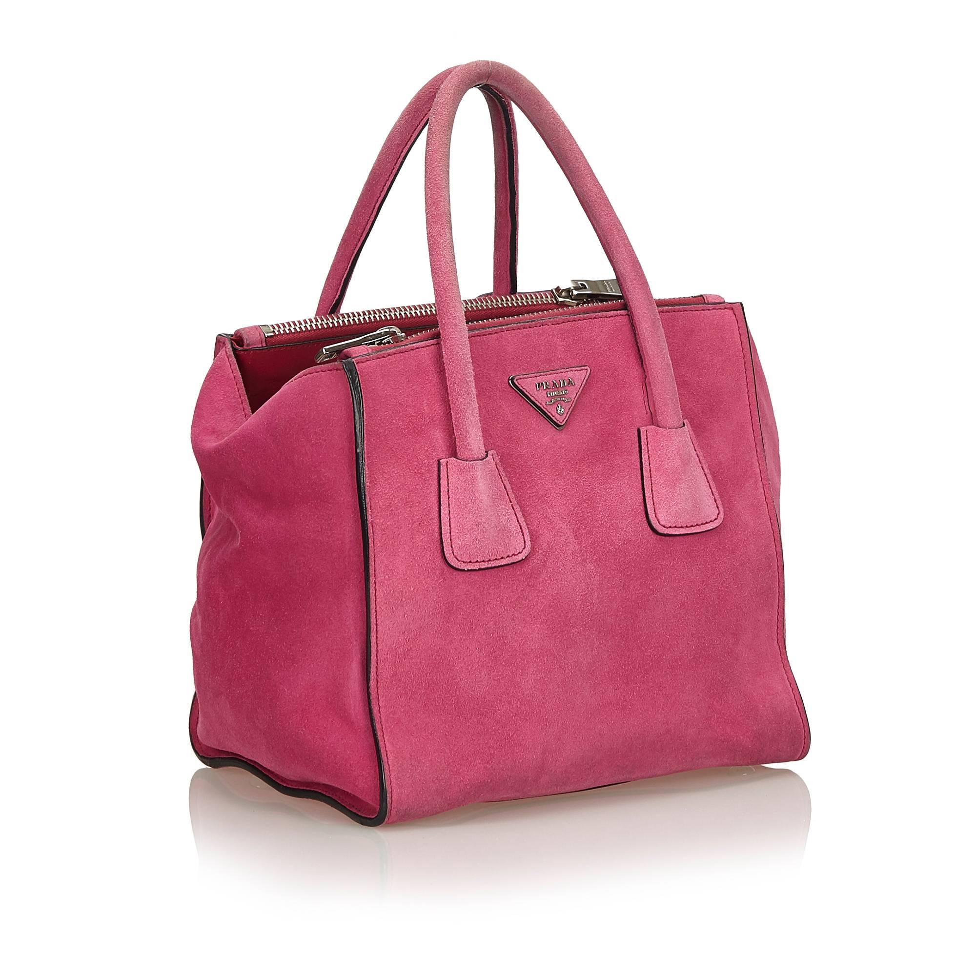 The Twin Pocket Bag features a suede leather body, rolled leather handles, zip compartments, button clasp closure, and interior zip pocket. 

It carries a B condition rating.

Dimensions: 
Length 23 cm
Width 24 cm
Depth 18 cm
Shoulder Drop 12