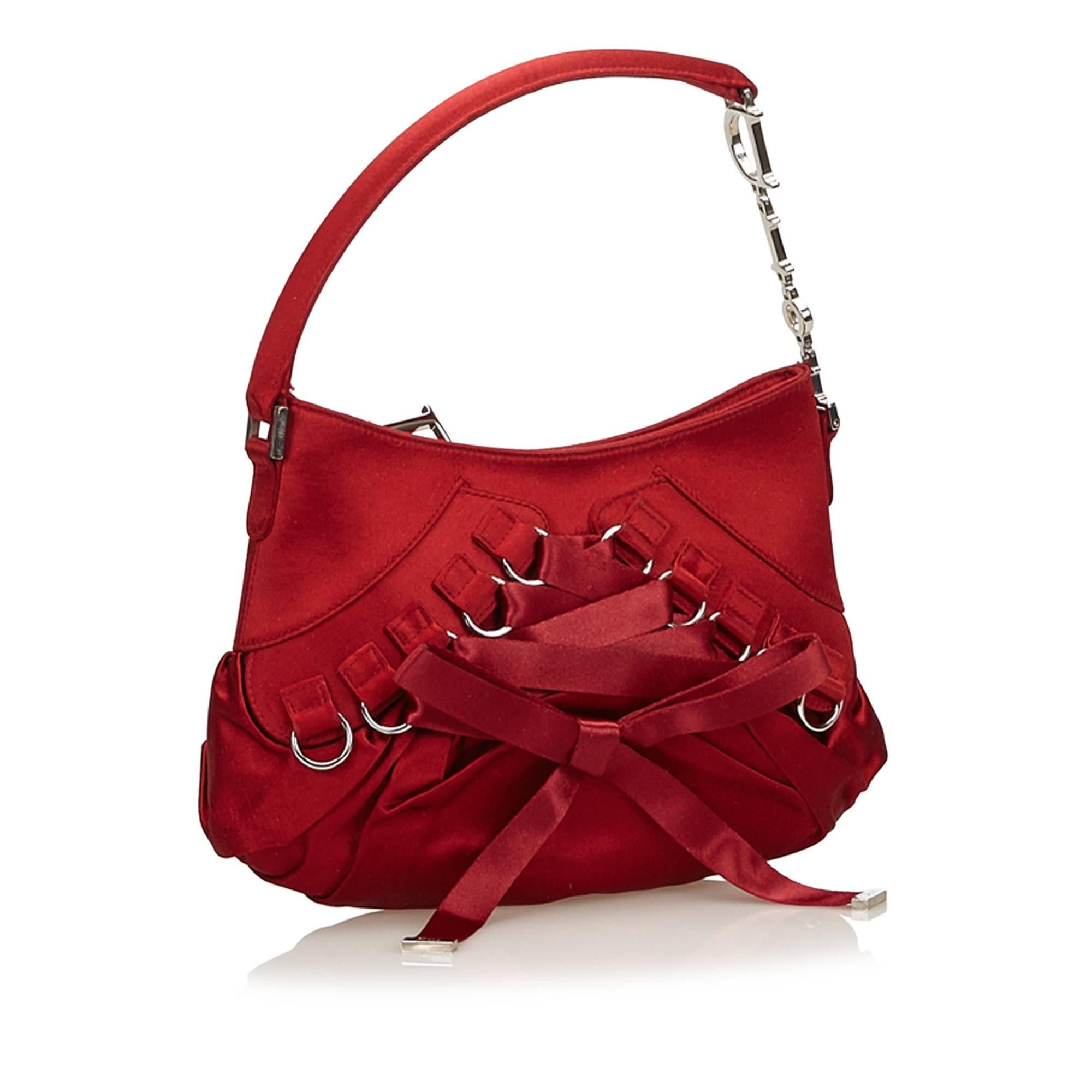 This handbag features a satin body with corset embellishment, flat handle, top zip closure, and interior slip pocket.

It carries a A condition rating.

Dimensions: 
Length 14 cm
Width 22 cm
Depth 6 cm
Hand Drop 12 

Inclusions: No longer comes with