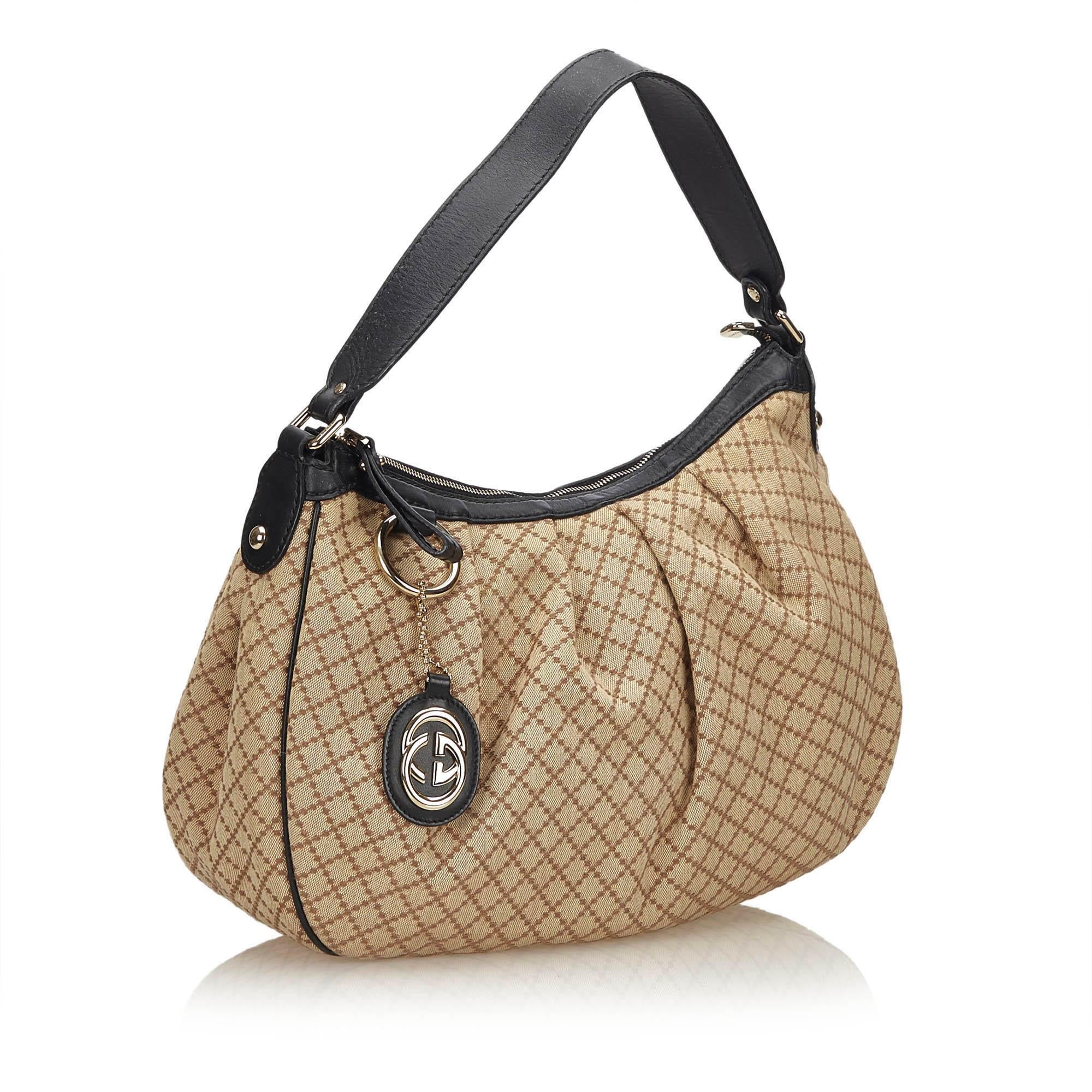 This Sukey features a canvas body, flat leather strap, top zip closure and interior zip and slip pockets.

It carries a B+ condition rating.

Dimensions: 
Length 27 cm
Width 34 cm
Depth 11 cm
Shoulder Drop 17 

Inclusions: Charm

Color: Brown x