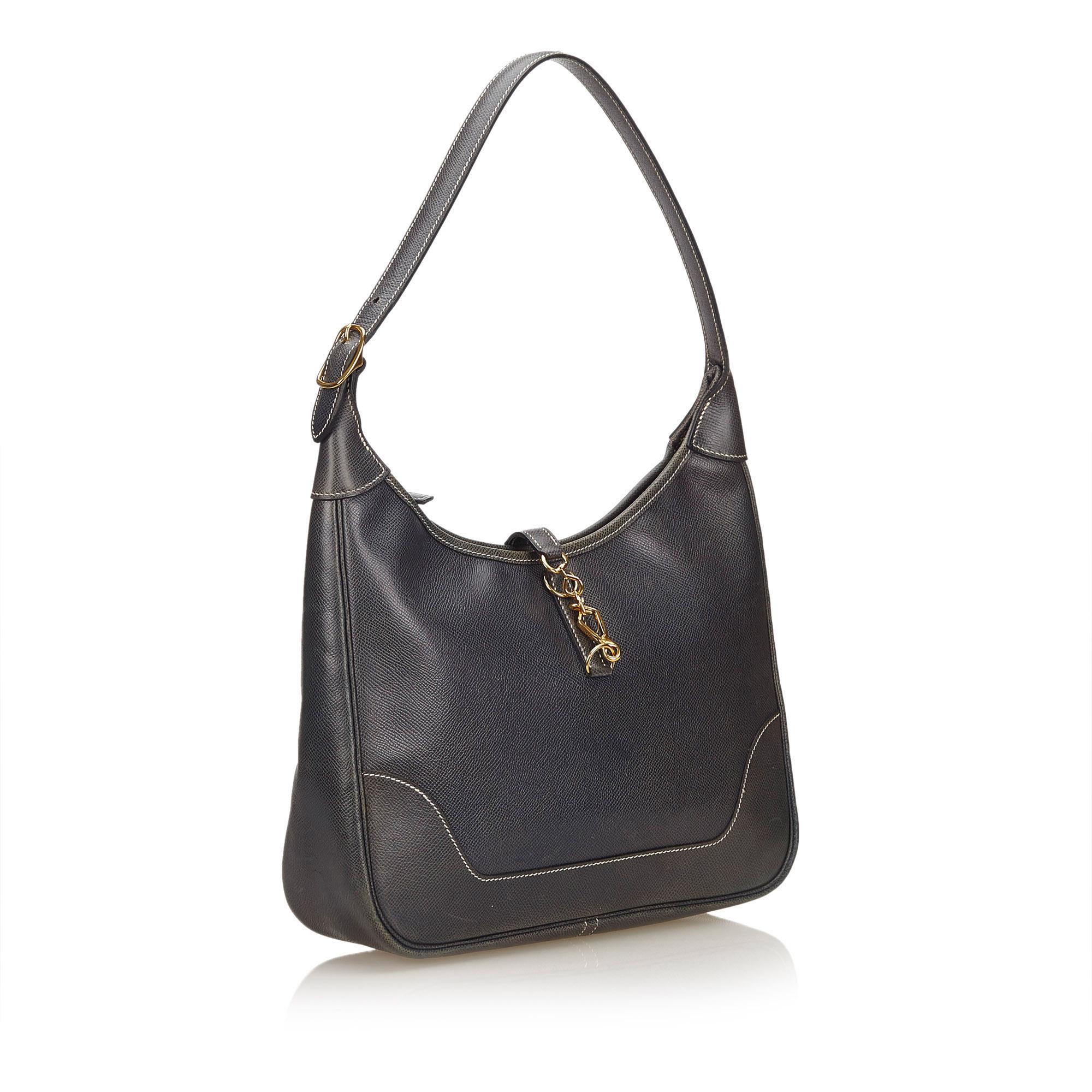 The Trim 31 features a leather body, a flat shoulder strap, a top strap with a lobster claw closure, a top zip closure, and interior zip and slip pockets.

It carries a B condition rating.

Dimensions: 
Length 28 cm
Width 30 cm
Depth 6 cm
Shoulder