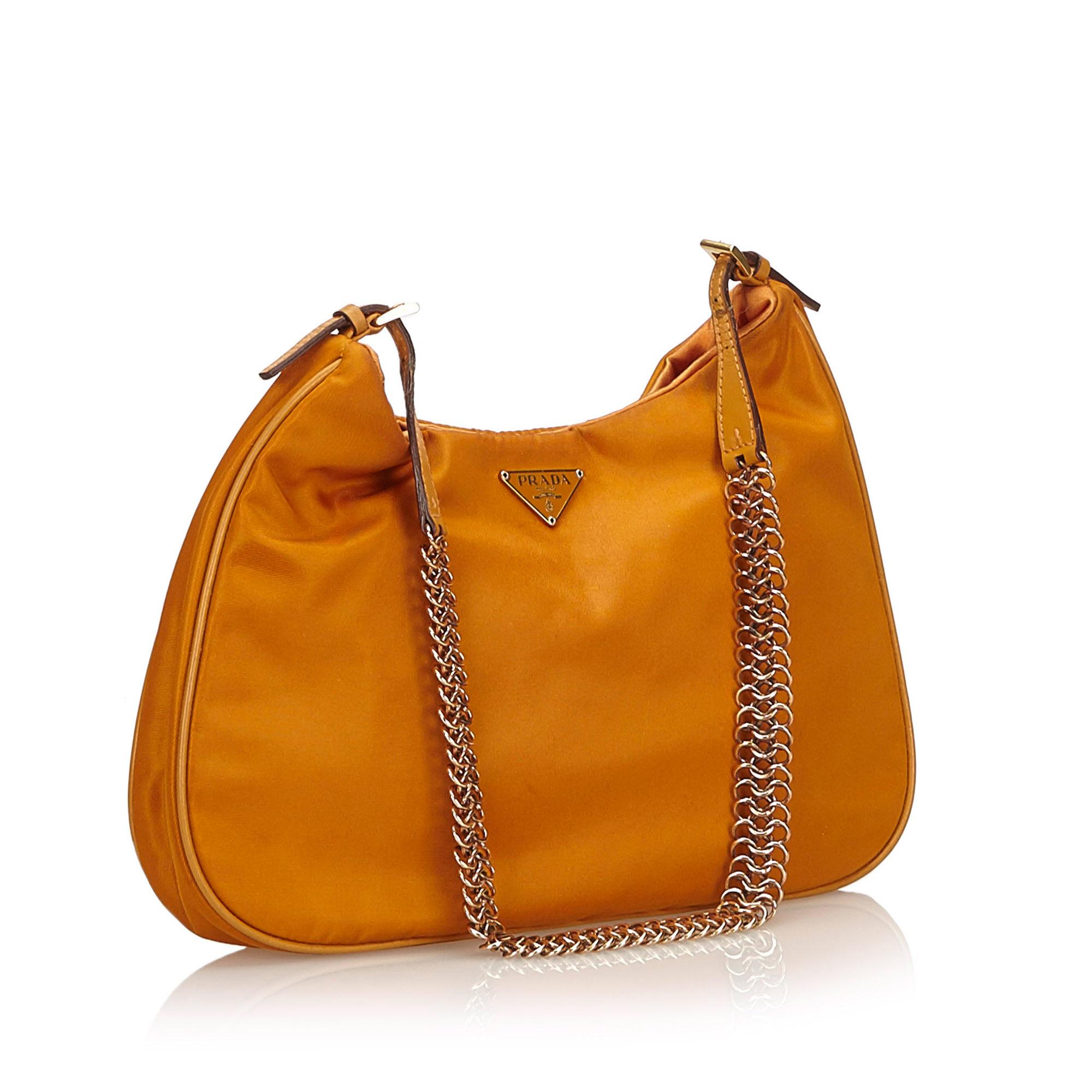 This shoulder bag features a nylon body, a gold-tone shoulder chain, an open top with magnetic closure, and an interior slip pocket.

It carries a AB condition rating.

Dimensions: 
Length 18 cm
Width 26 cm
Depth 3 cm
Shoulder Drop 27 

Inclusions: