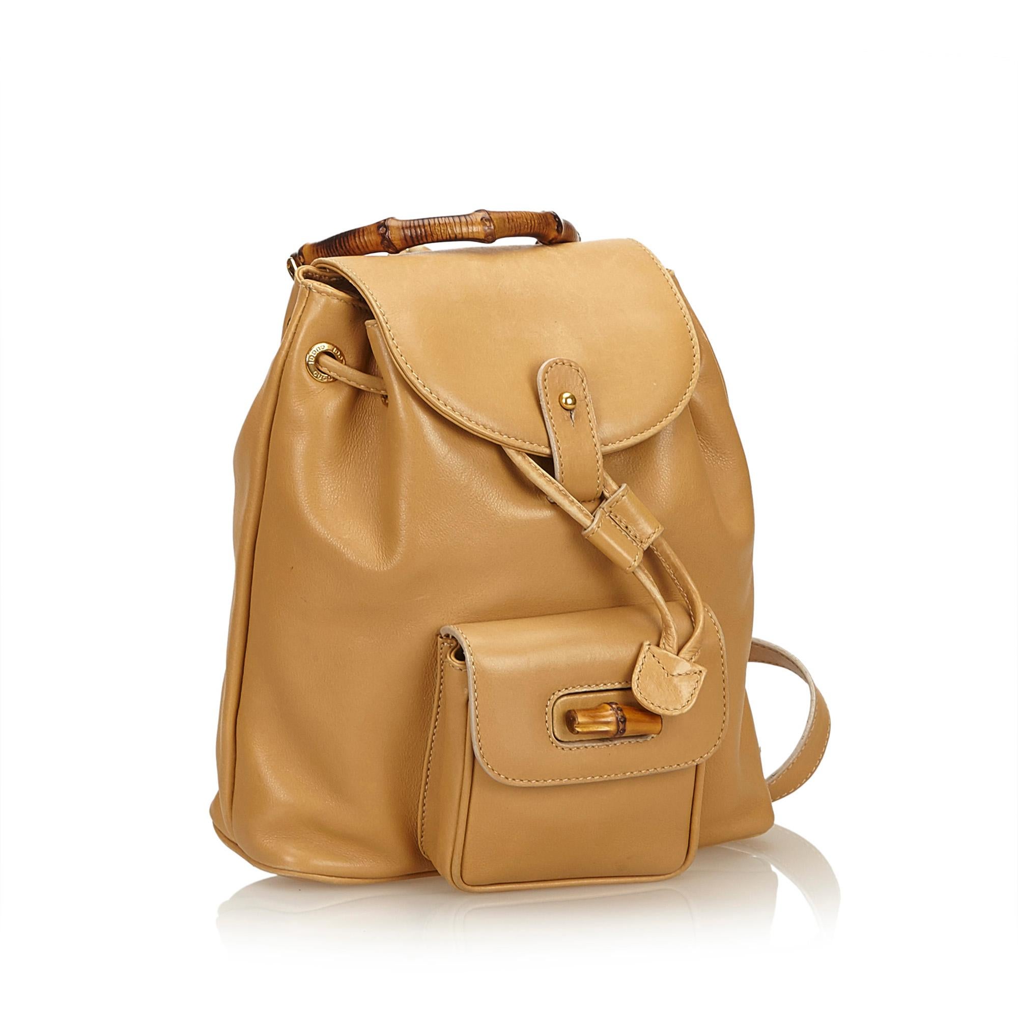 This backpack features a leather body, flat back straps, bamboo top handle, top flap, drawstring closure, exterior flap pocket with bamboo twist lock closure, and interior zip pocket.

It carries a B condition rating.

Dimensions: 
Length 25