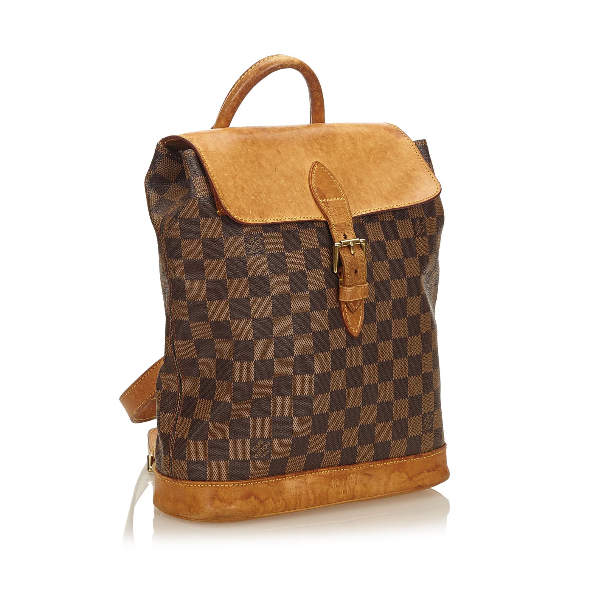 The Arlequin Backpack features a damier canvas body, vachetta trim, rolled leather top handle, flat back straps, front flap with buckle, and interior slip pocket.

It carries a B condition rating.

Dimensions: 
Length 30.00 cm
Width 28.00 cm
Depth