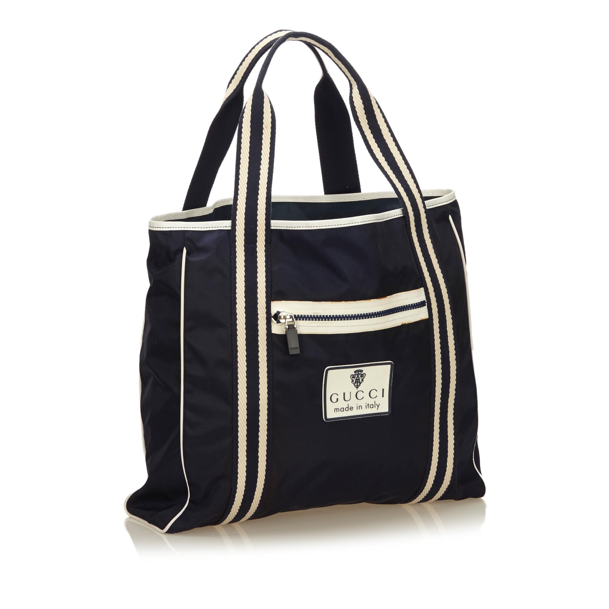 This tote bag features a nylon body, flat shoulder straps, open top, exterior zip pocket, and an interior pocket.

It carries a B+ condition rating.

Dimensions: 
Length 36.00 cm
Width 44.00 cm
Depth 6.00 cm
Shoulder Drop 16.00 cm

Inclusions: No