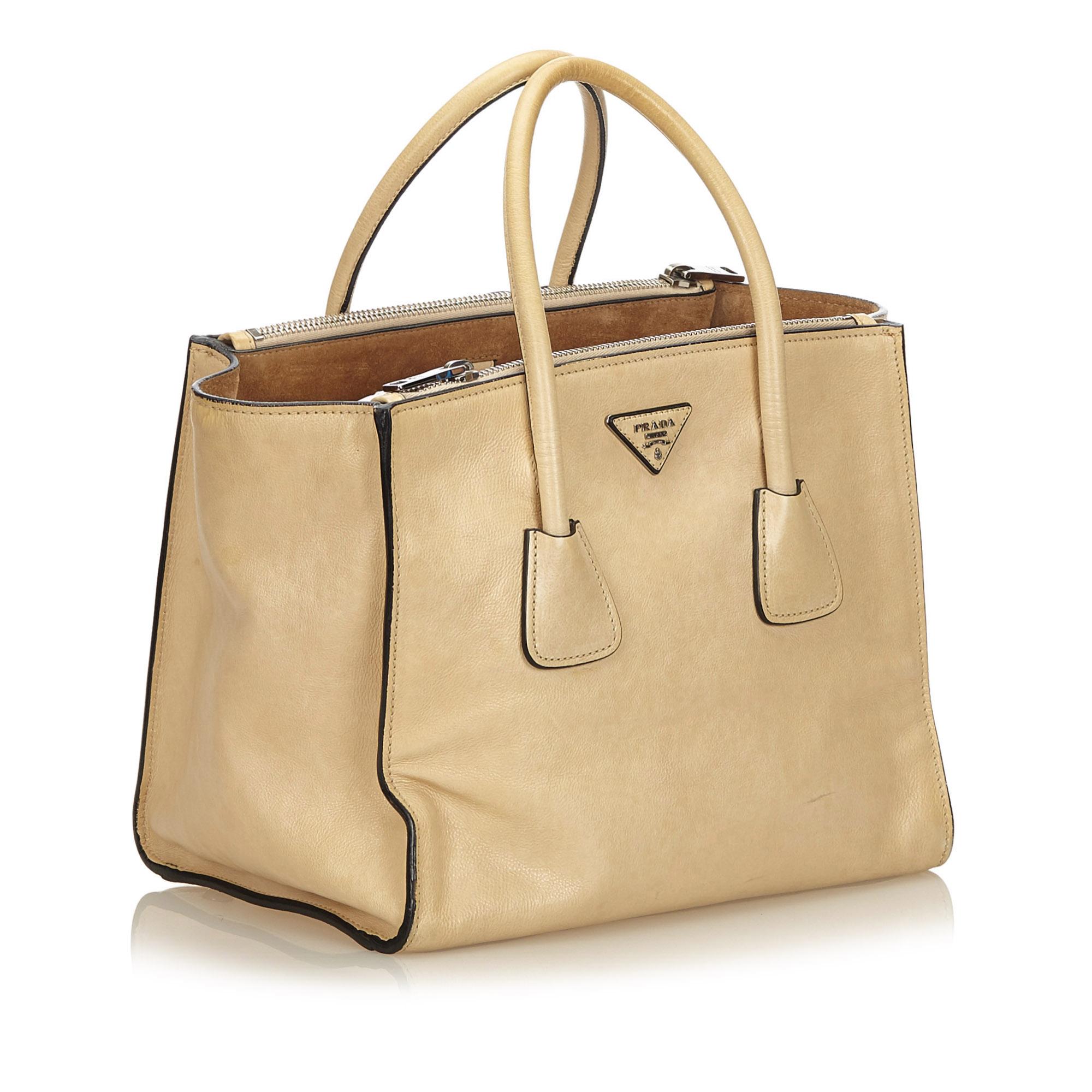 This tote features a calf leather body, rolled handles, open top with magnetic snap button closure, exterior zip compartments, and interior zip pockets.

It carries a B+ condition rating.

Dimensions: 
Length 24.00 cm
Width 28.00 cm
Depth 18.00
