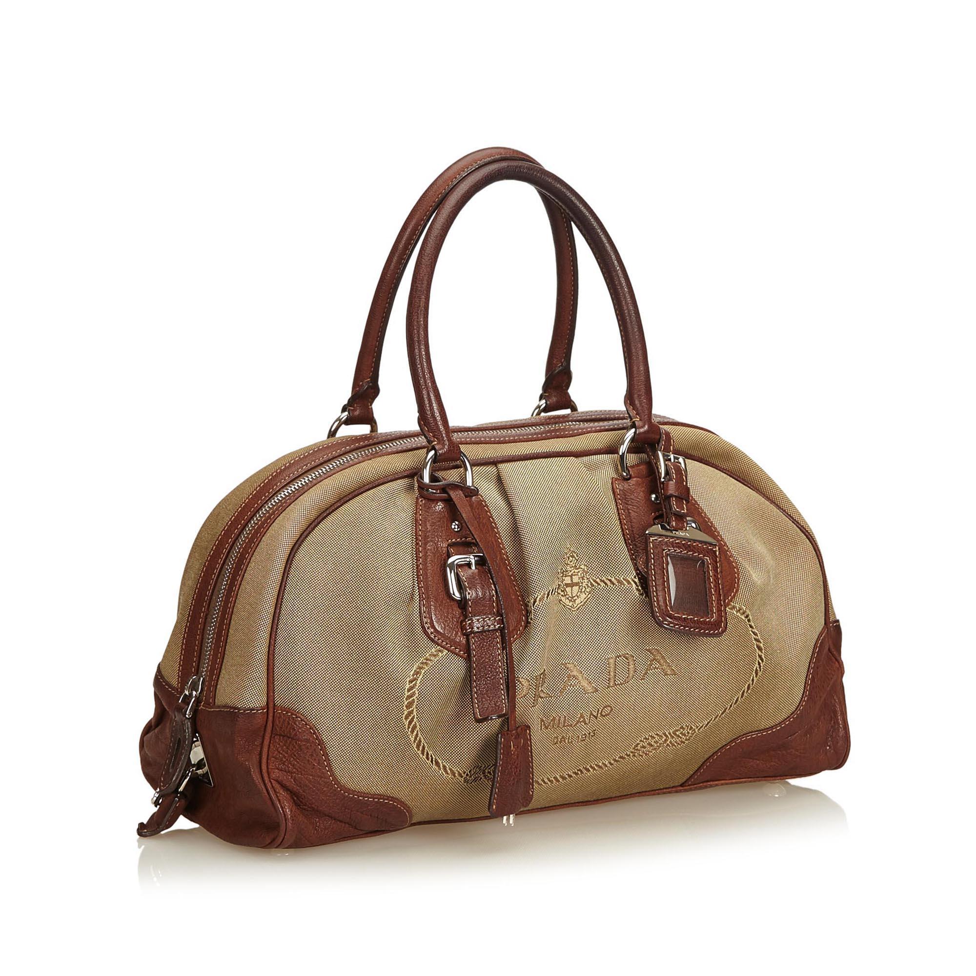 This handbag features a canvas body with leather trim, rolled leather handles, top zip closure, and interior zip pocket.

It carries a B condition rating.

Dimensions: 
Length 23.00 cm
Width 35.00 cm
Depth 16.00 cm
Hand Drop 20.00 cm

Inclusions: