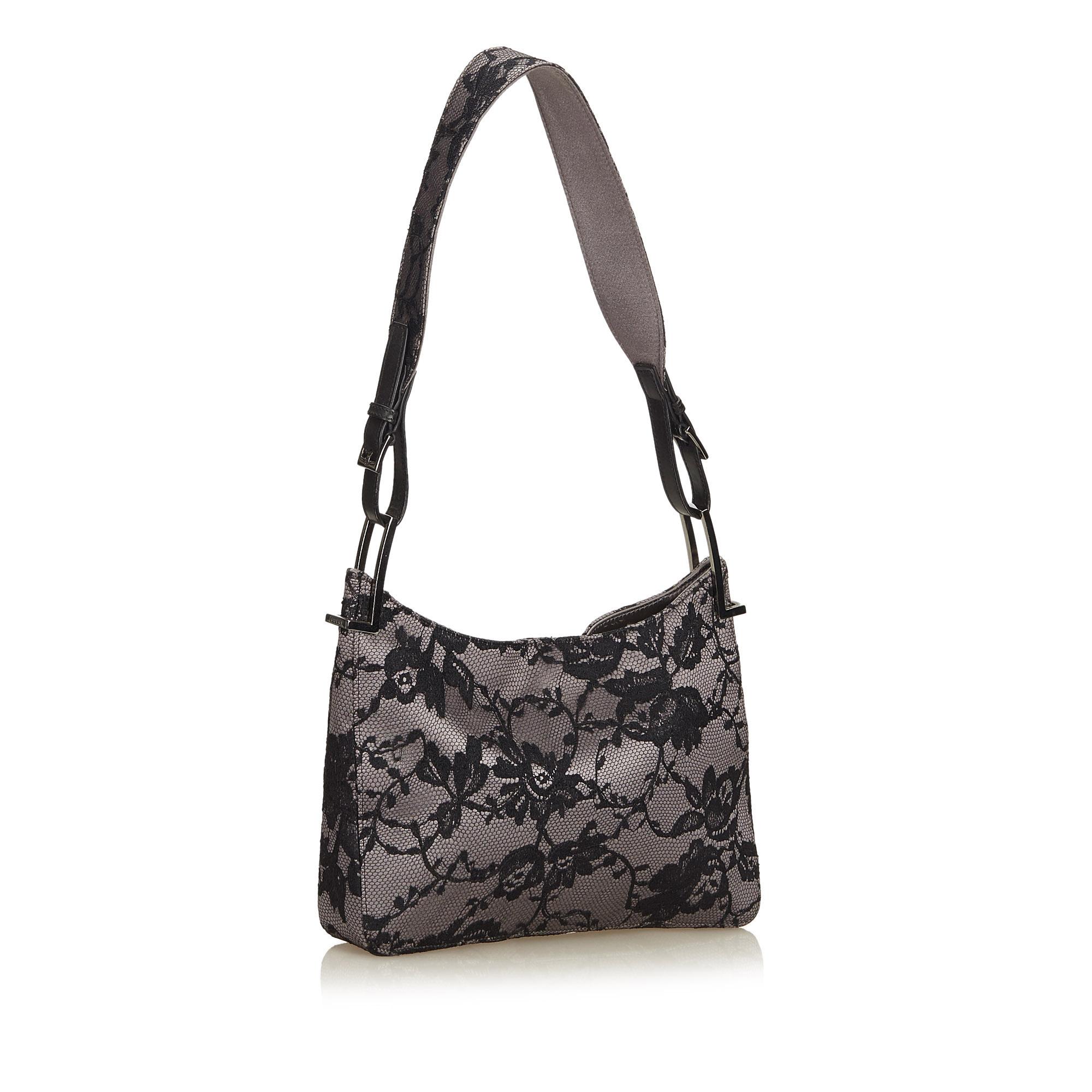 This baguette bag features a satin and lace body, flat shoulder strap, open top with magnetic snap closure, and an interior zip pocket.

It carries a AB condition rating.

Dimensions: 
Length 16.00 cm
Width 25.00 cm
Depth 4.50 cm
Shoulder Drop 25.50