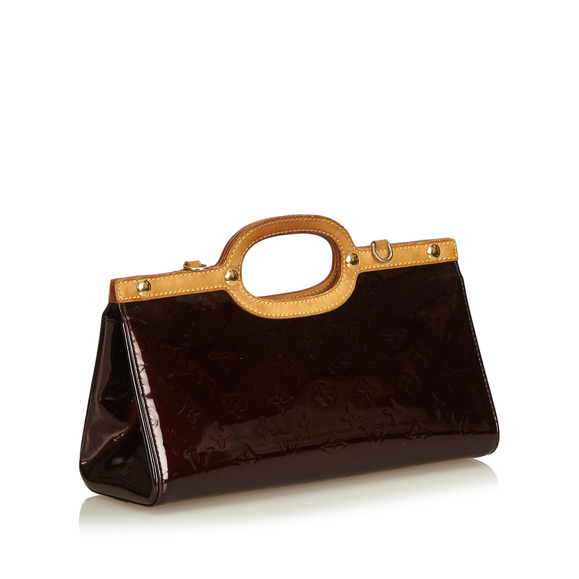The Roxbury Drive features a vernis leather body, a leather top and an detachable shoulder strap, an open top, and an interior slip pocket.

It carries a B+ condition rating.

Dimensions: 
Length 17.00 cm
Width 31.00 cm
Depth 10.00 cm
Shoulder Drop