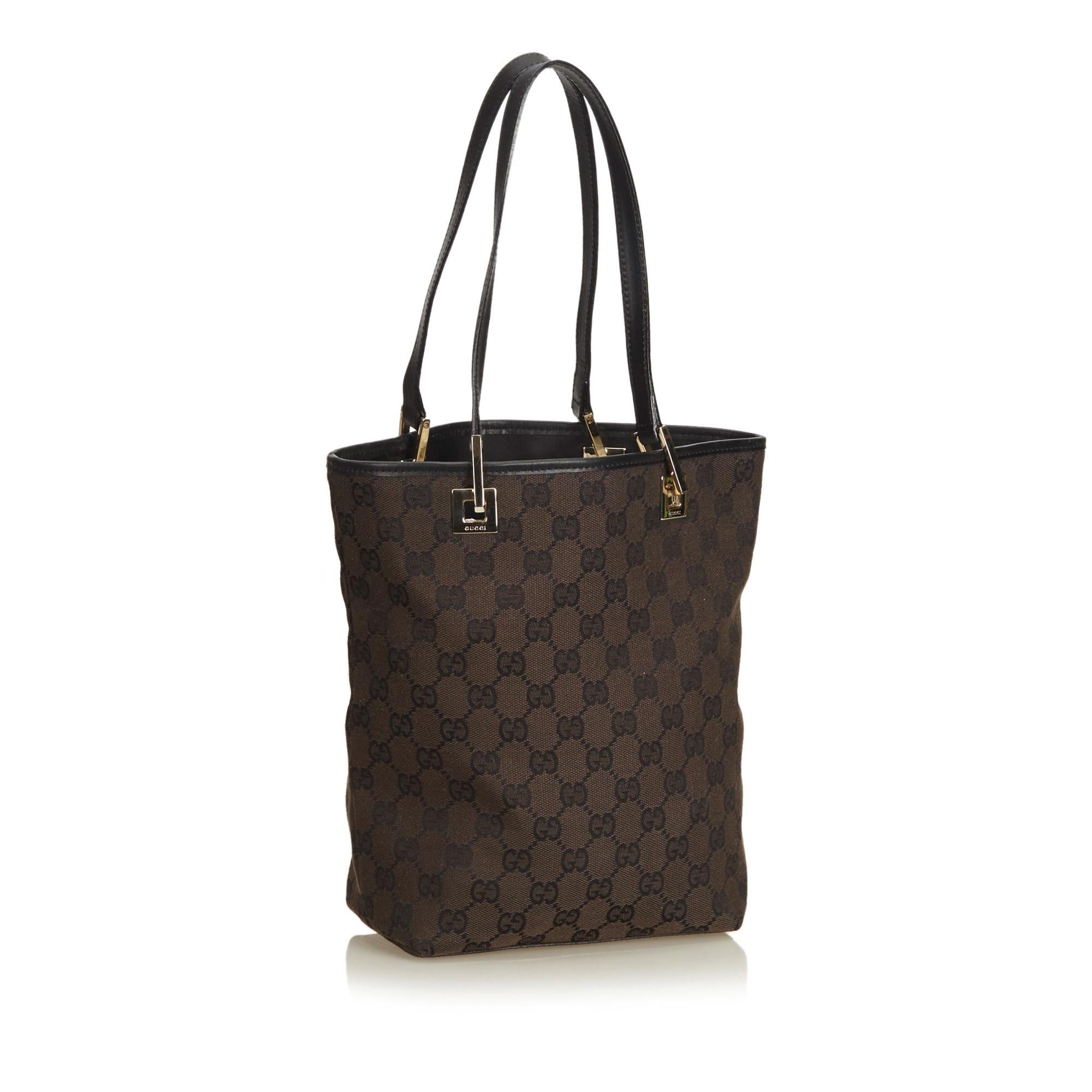 This tote features a canvas body, flat leather handles, an open top, and an interior zip pocket.

It carries a AB condition rating.

Dimensions: 
Length 24.00 cm
Width 26.00 cm
Depth 10.00 cm
Shoulder Drop 19.00 cm

Inclusions: No longer comes with