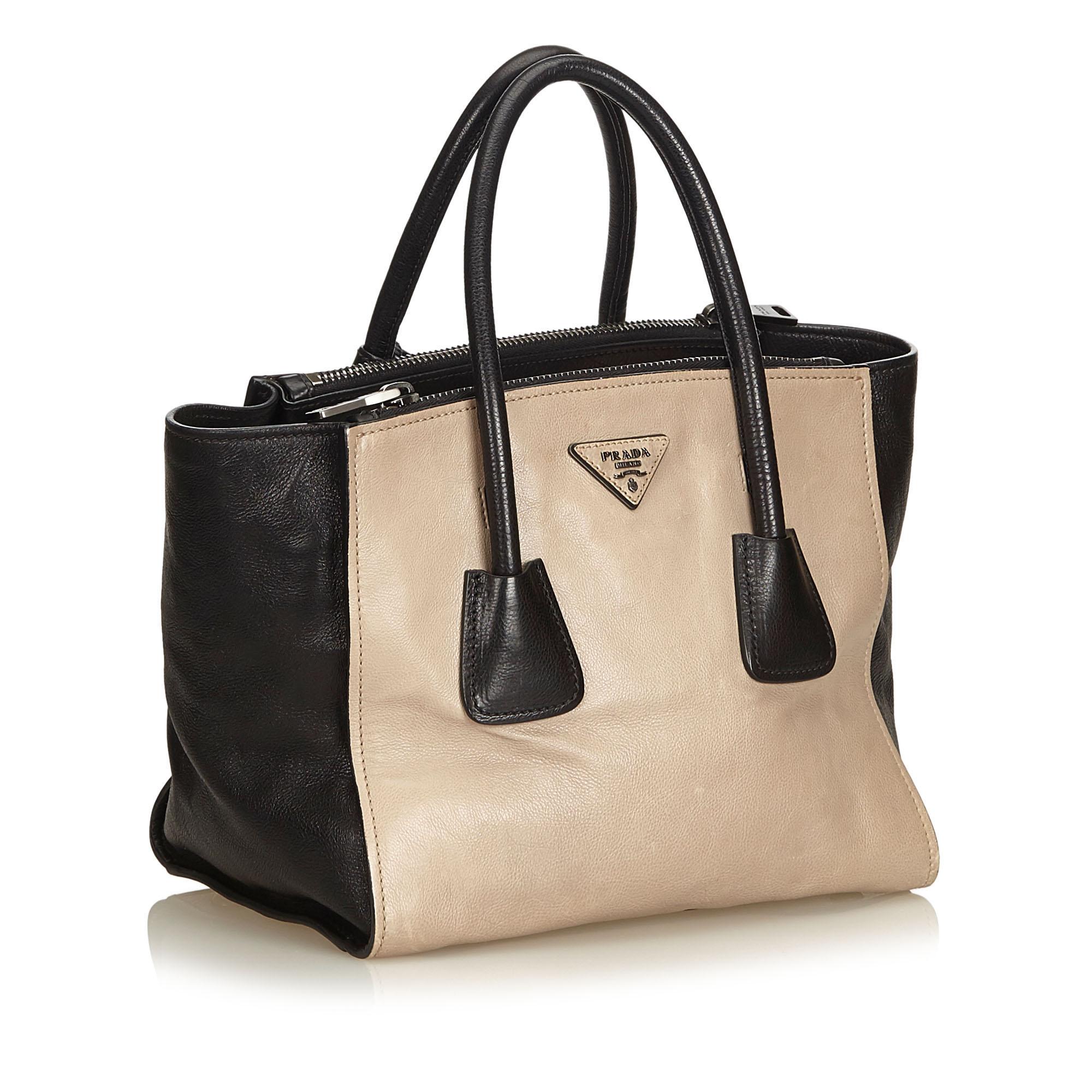 This tote features a calf leather body, rolled handles, open top with magnetic snap button closure, exterior zip compartments, and interior zip pockets.

It carries a B+ condition rating.

Dimensions: 
Length 22.00 cm
Width 39.00 cm
Depth 19.00